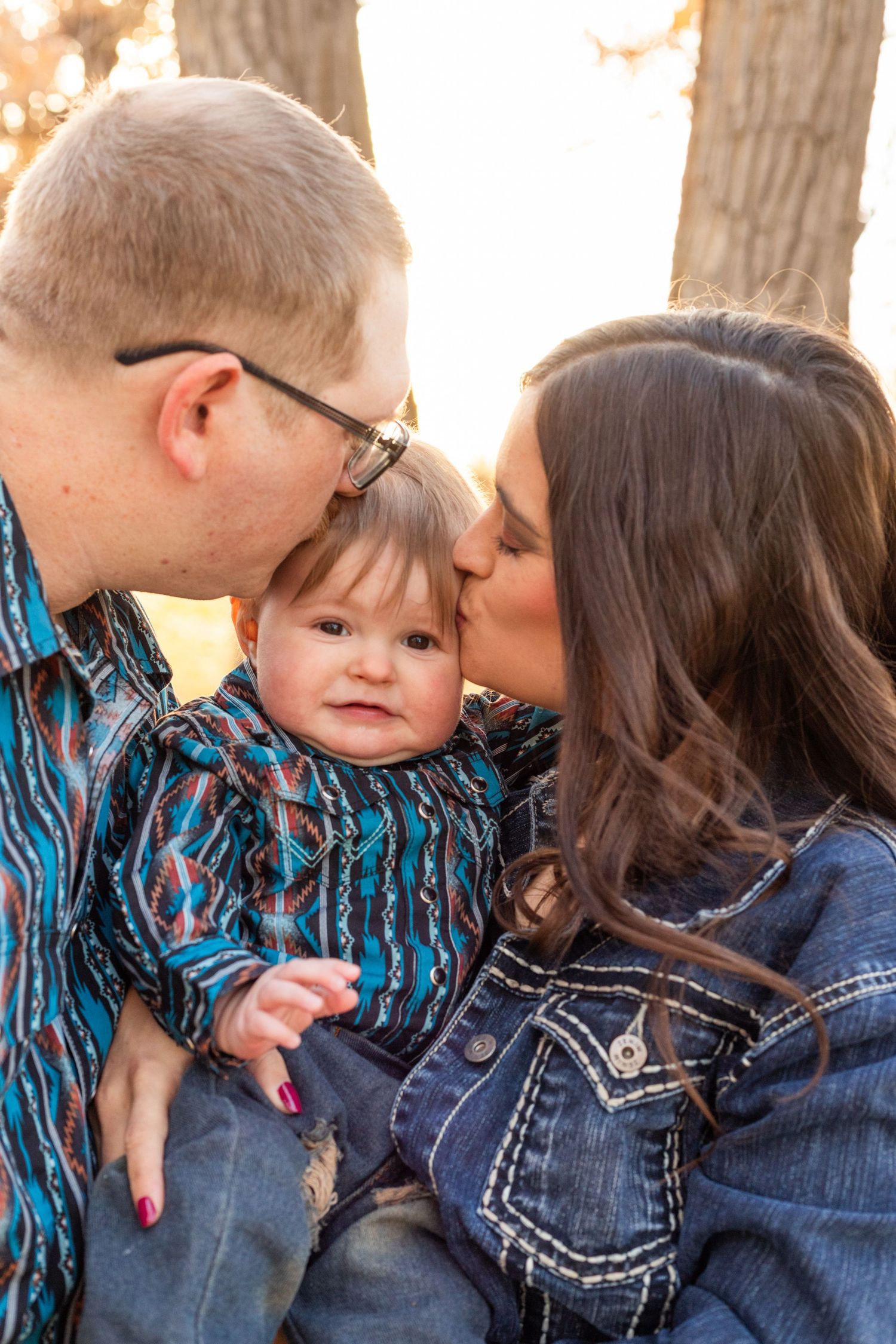 mom and dad kiss baby