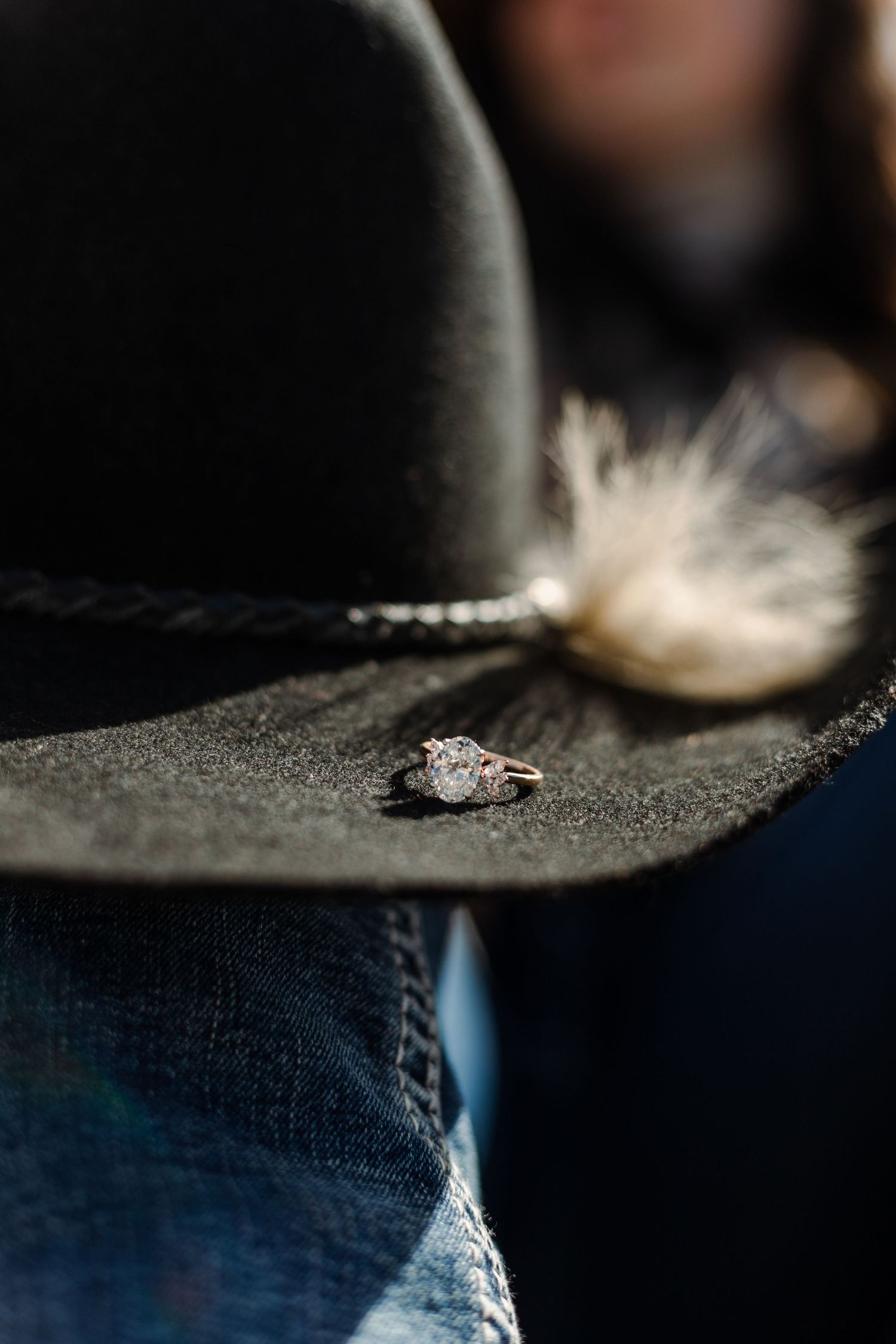 engagement ring shown up close on the brim of a cowboy hat