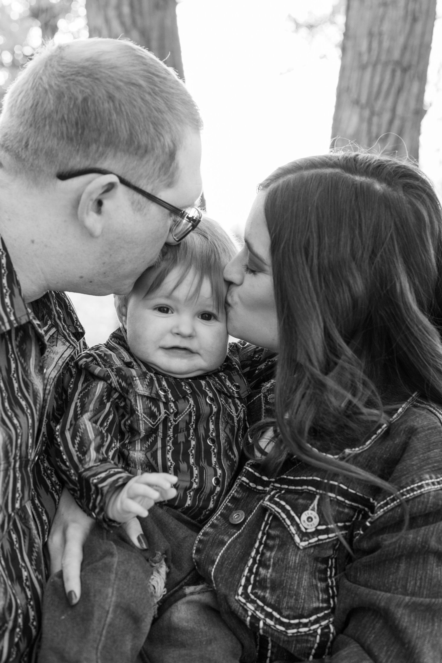 mom and dad kiss baby