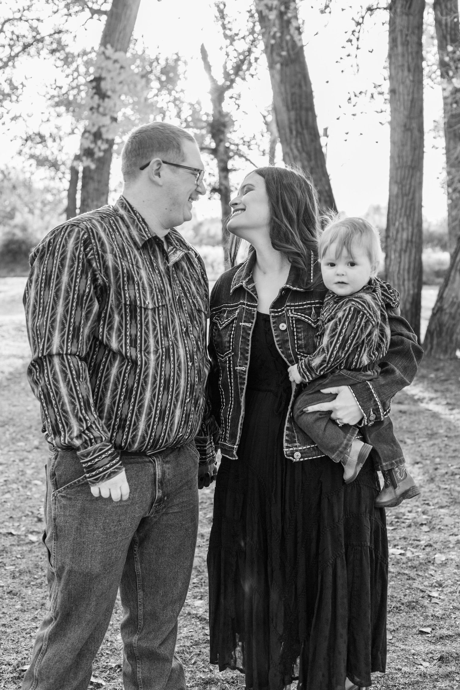 mom and dad look at eachother while baby looks at camera