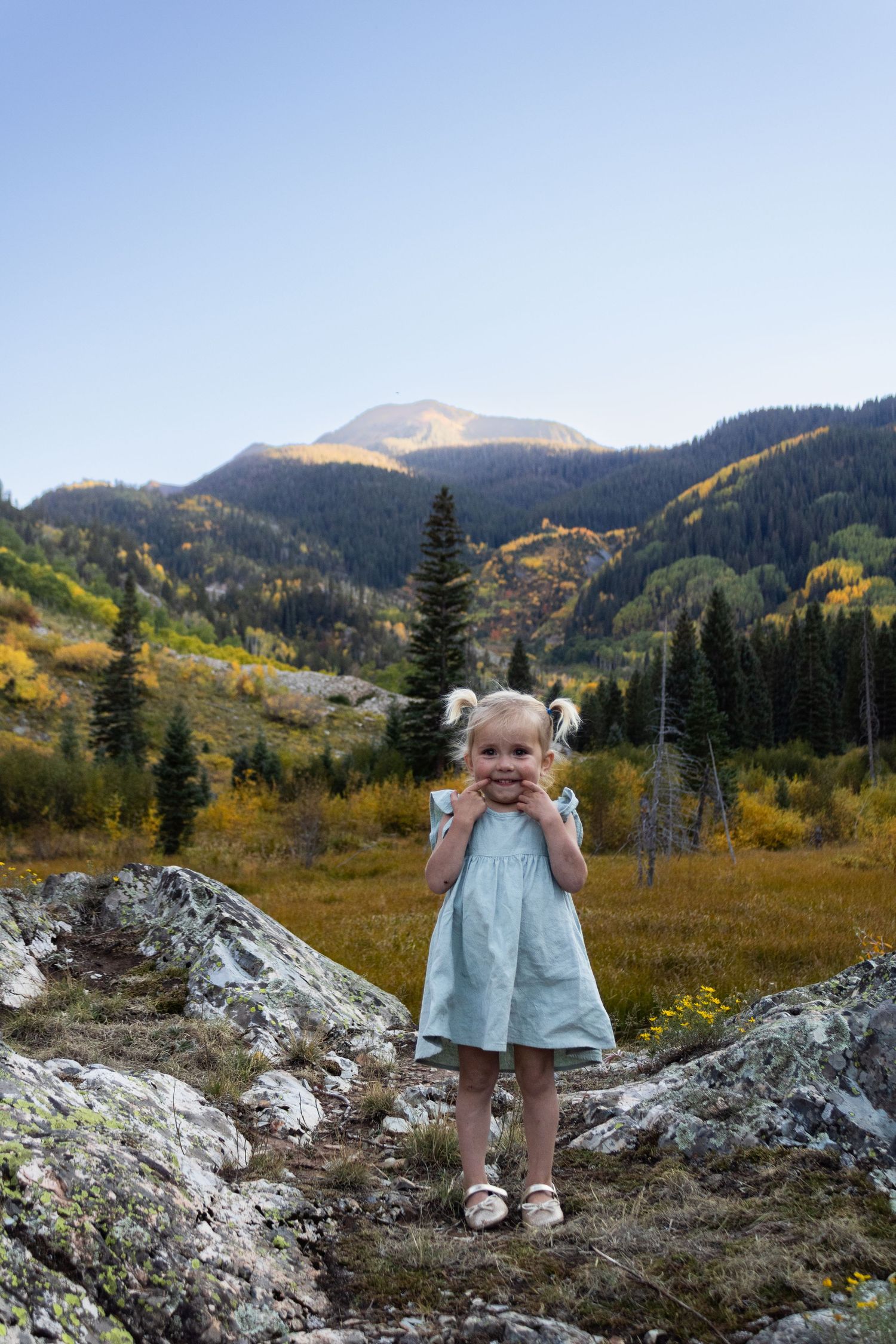 little girl poses in mountain scene