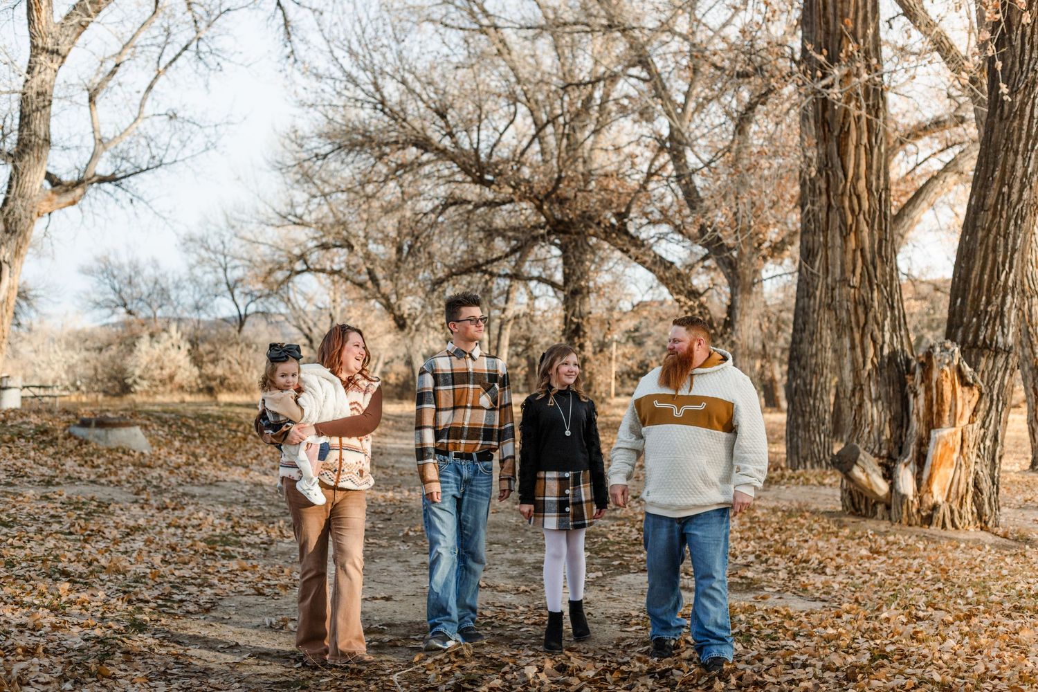 family walks down road in the fall