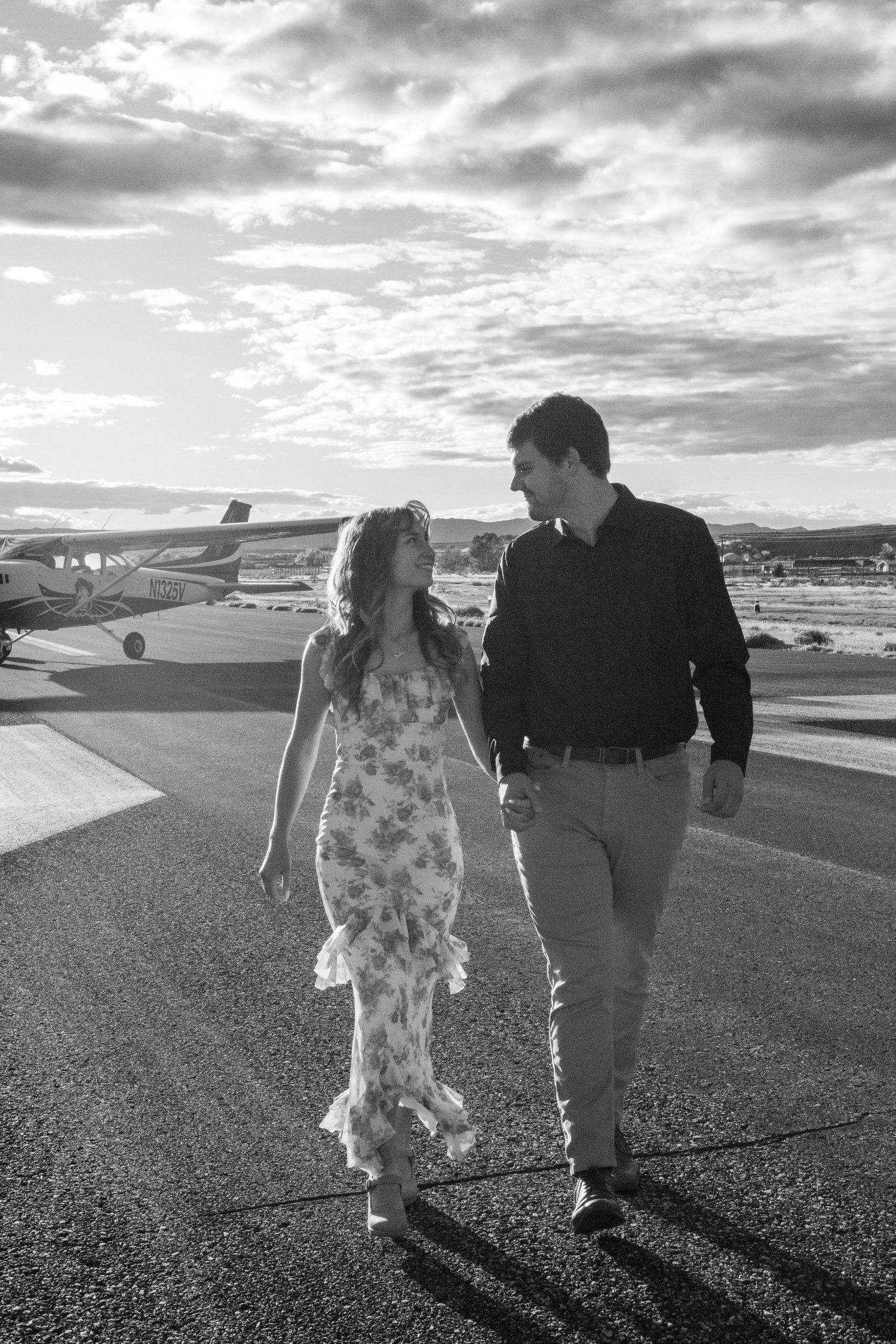couple walks together down an airplane runway