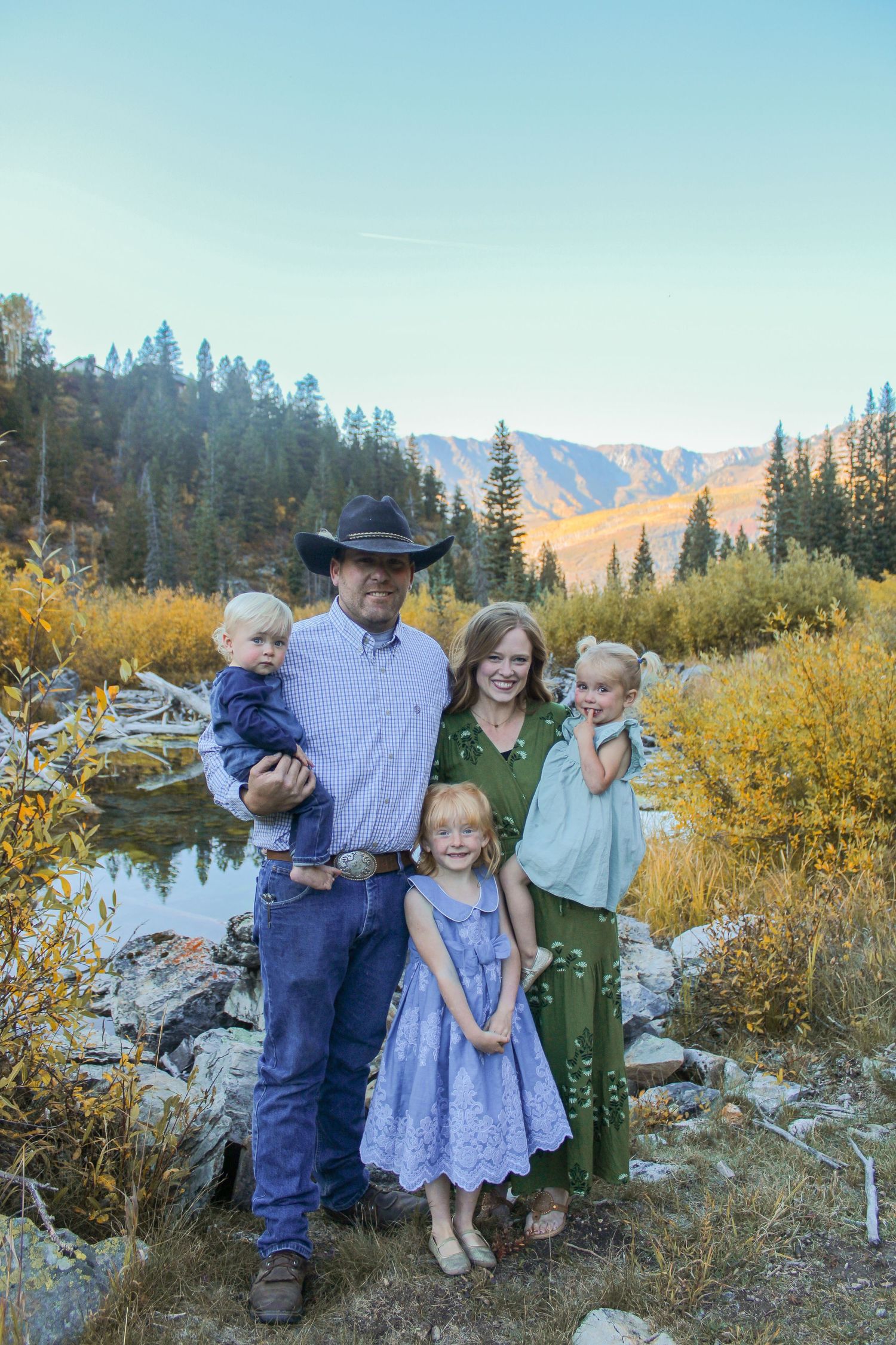 family poses in front of mountains