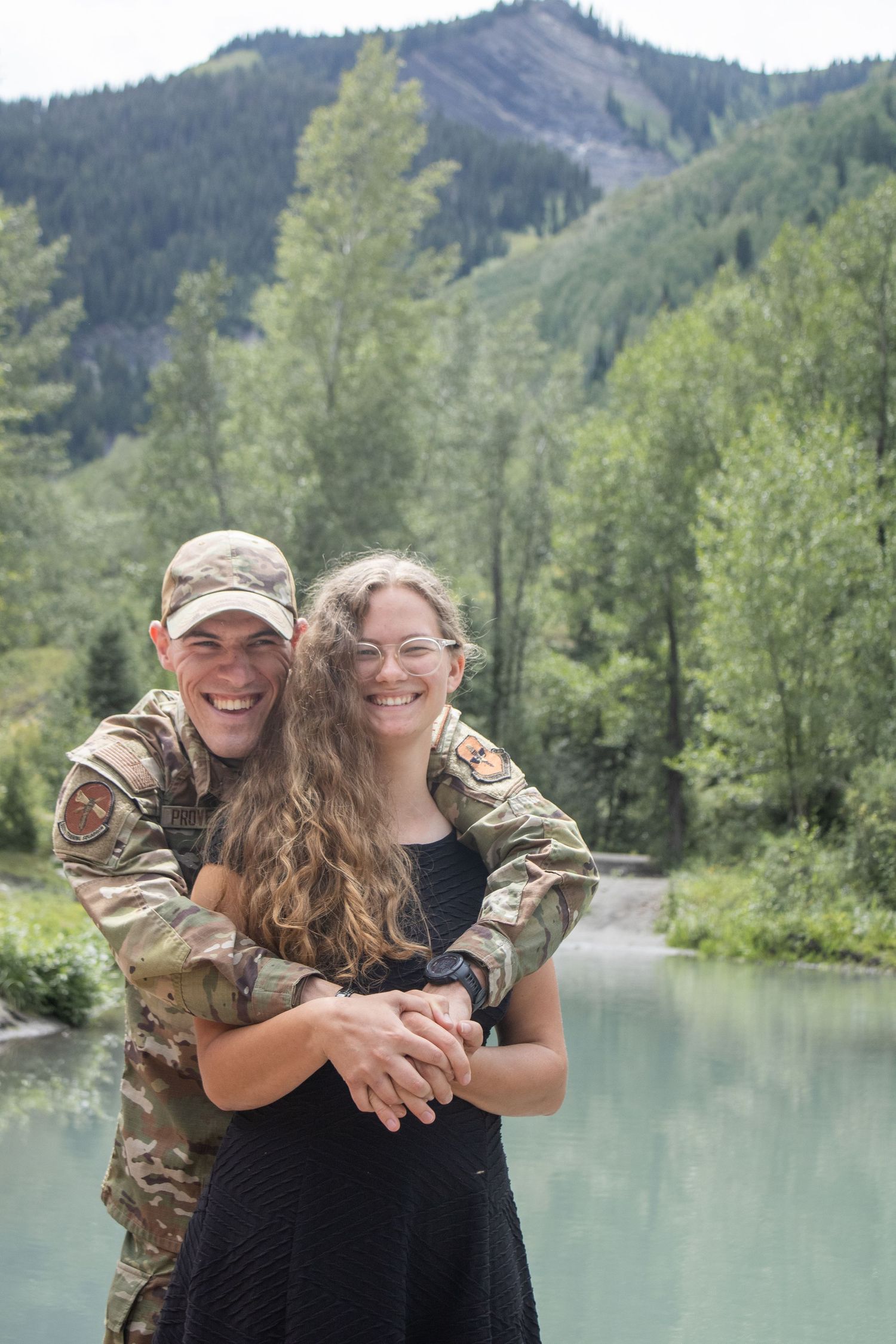 Couple poses together in front of pond.