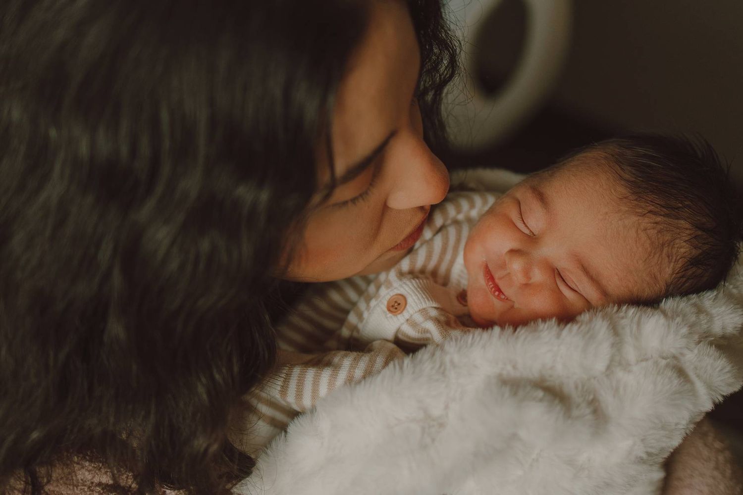 Dallas Fresh 48 photography session of a mother cuddling her newborn baby in the hospital during the first hours after birth.
