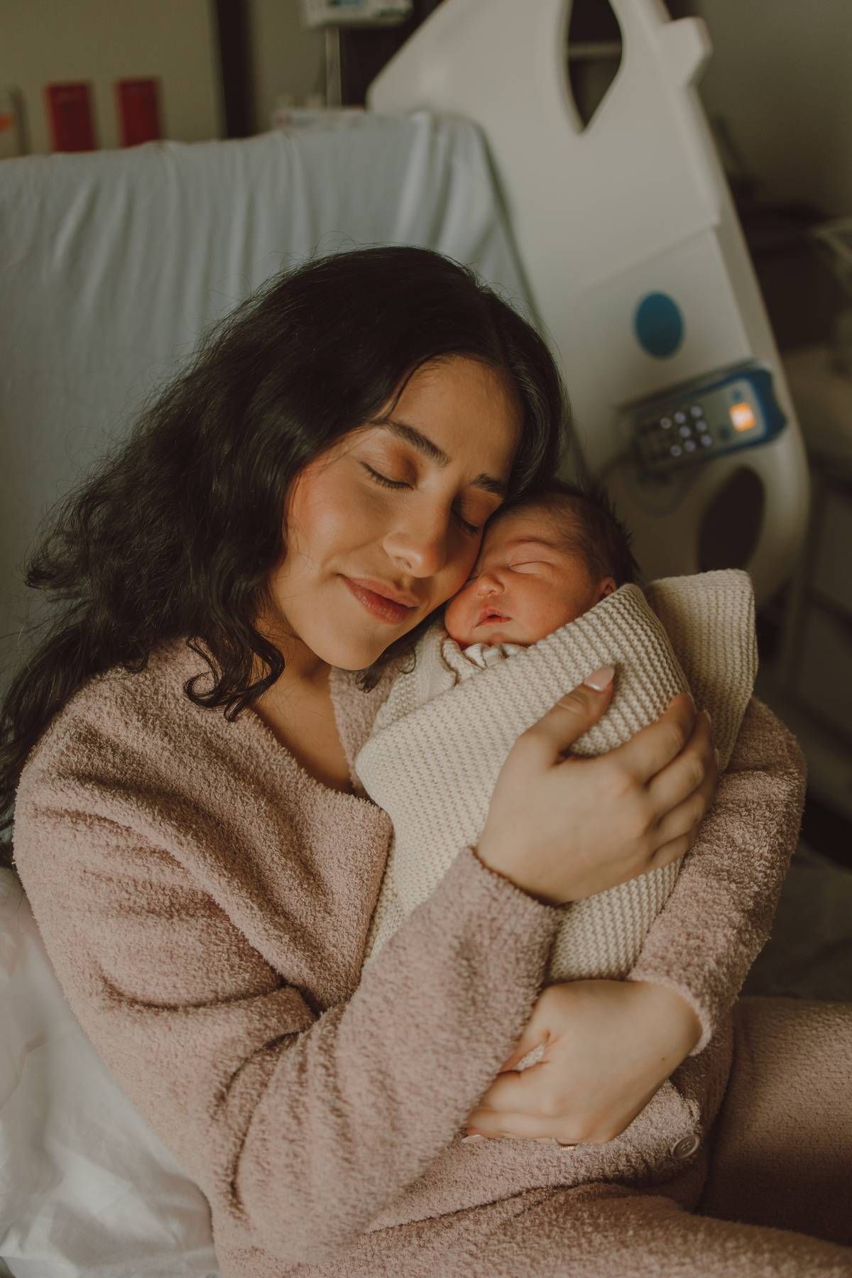 Dallas Fresh 48 photography session of a mother cuddling her newborn baby in the hospital during the first hours after birth.