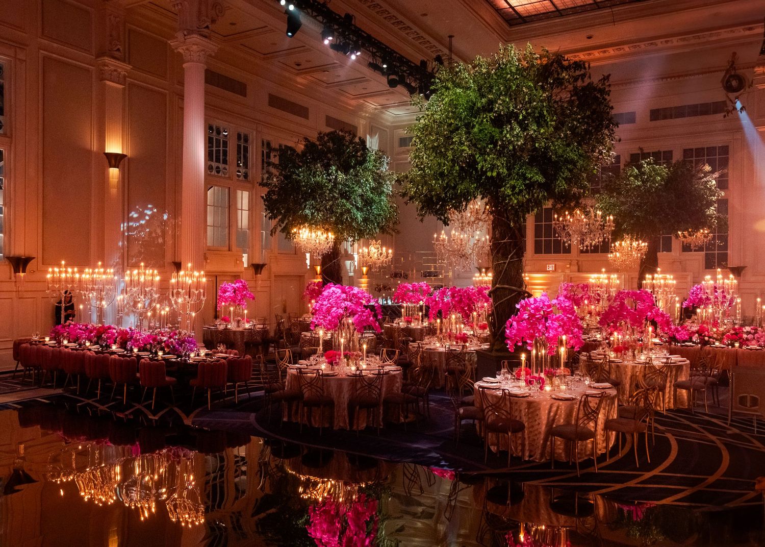 Elegant ballroom wedding reception with trees, candles, and pink floral centerpieces at Casa Cipriani, Manhattan.