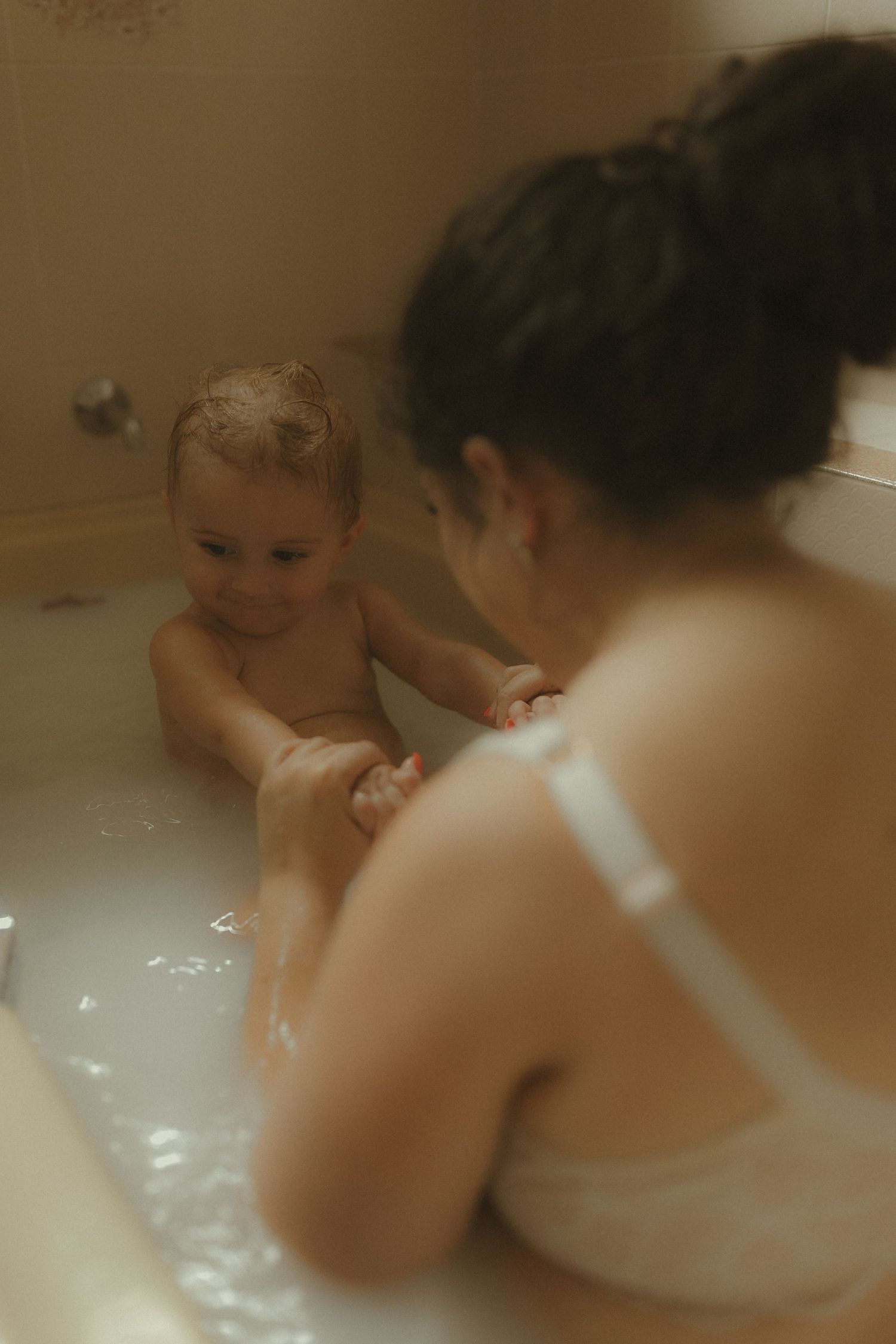 A tender bathtub moment showing a parent and child playing together in warm water.