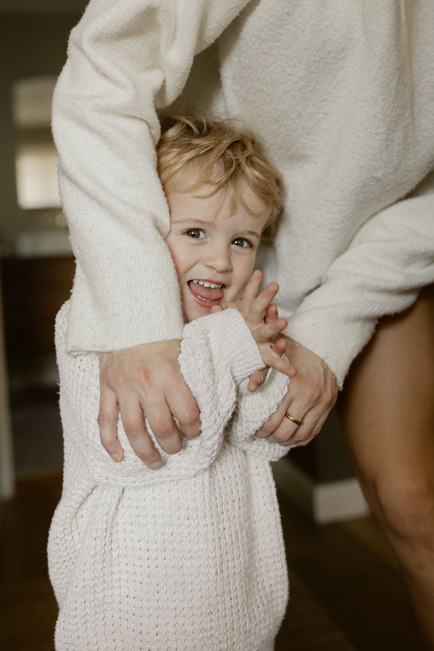 Candid moments captured in white knitwear against hardwood floors.