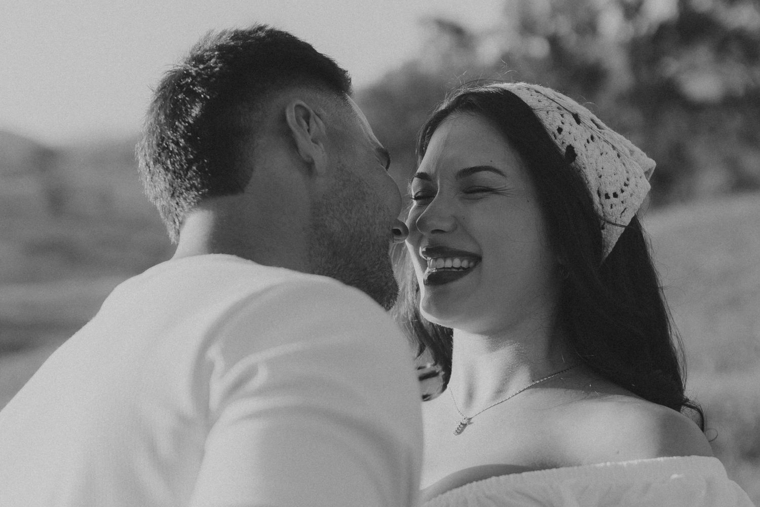 Black and white wedding photos showing intimate moments between a couple in a romantic outdoor setting.