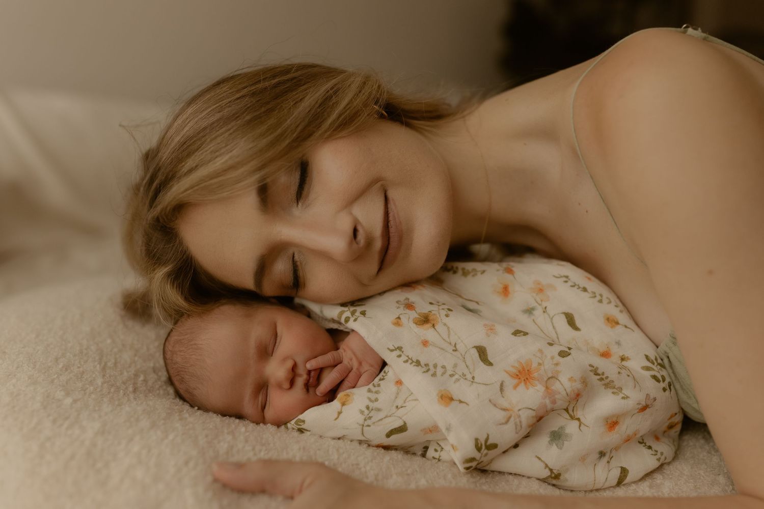 Family lying together on bed sharing intimate moment with newborn.