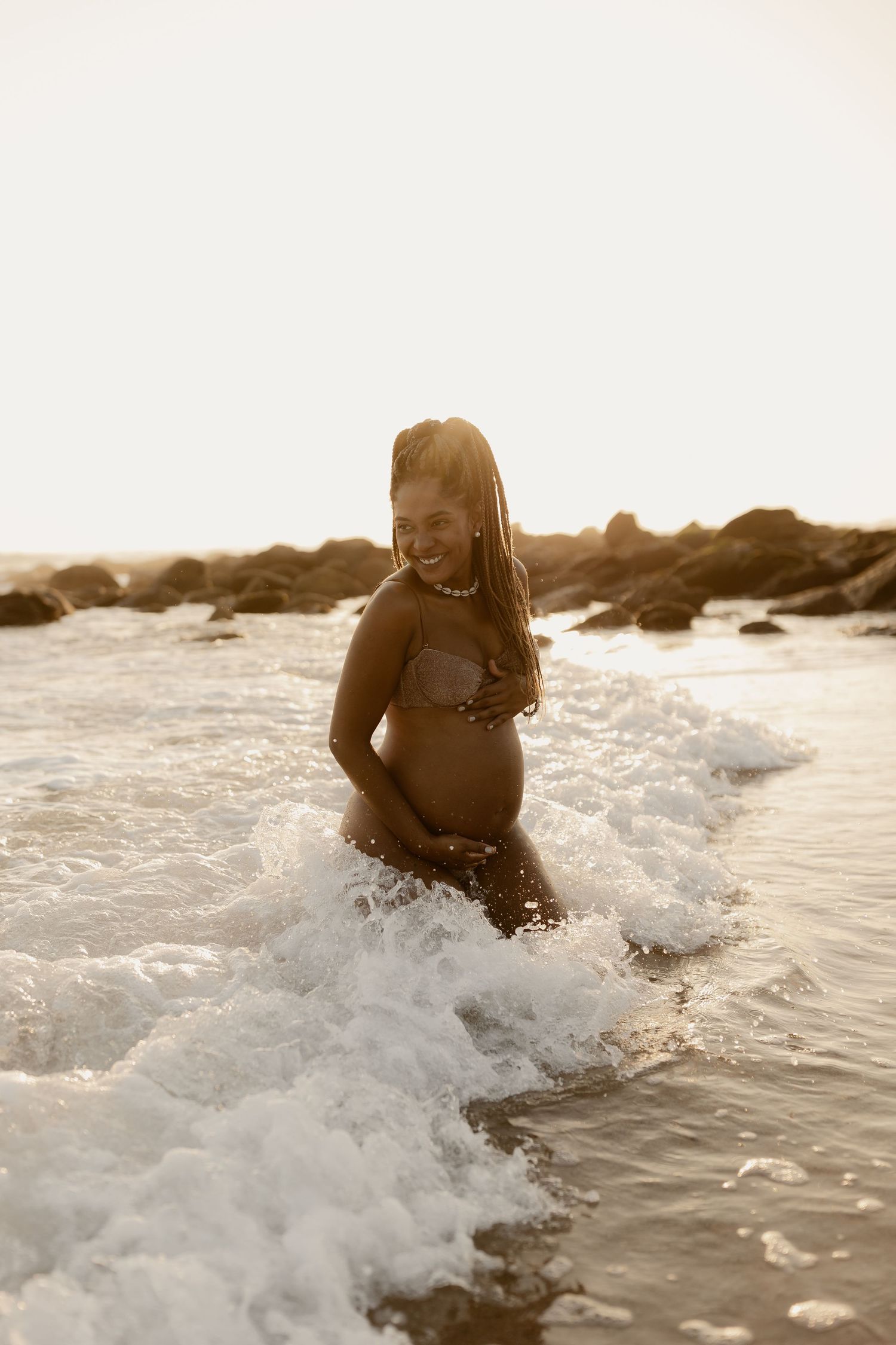 A sequence of five sepia-toned photos showing someone joyfully playing in ocean waves at the beach.