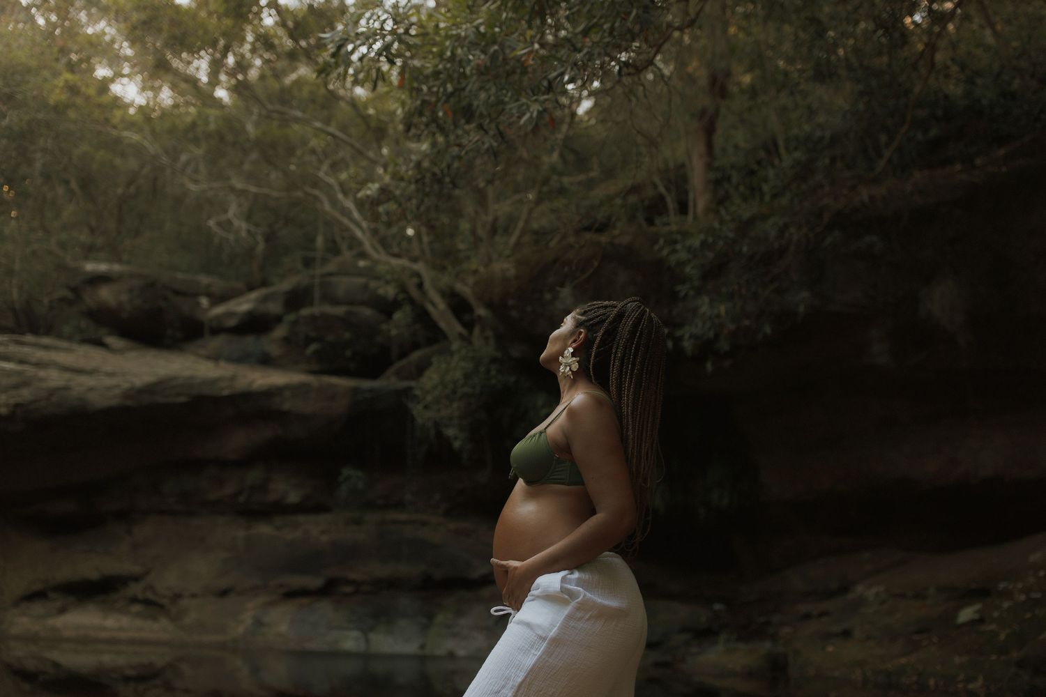 Intimate outdoor photoshoot in a wooded area with natural lighting and shadows.