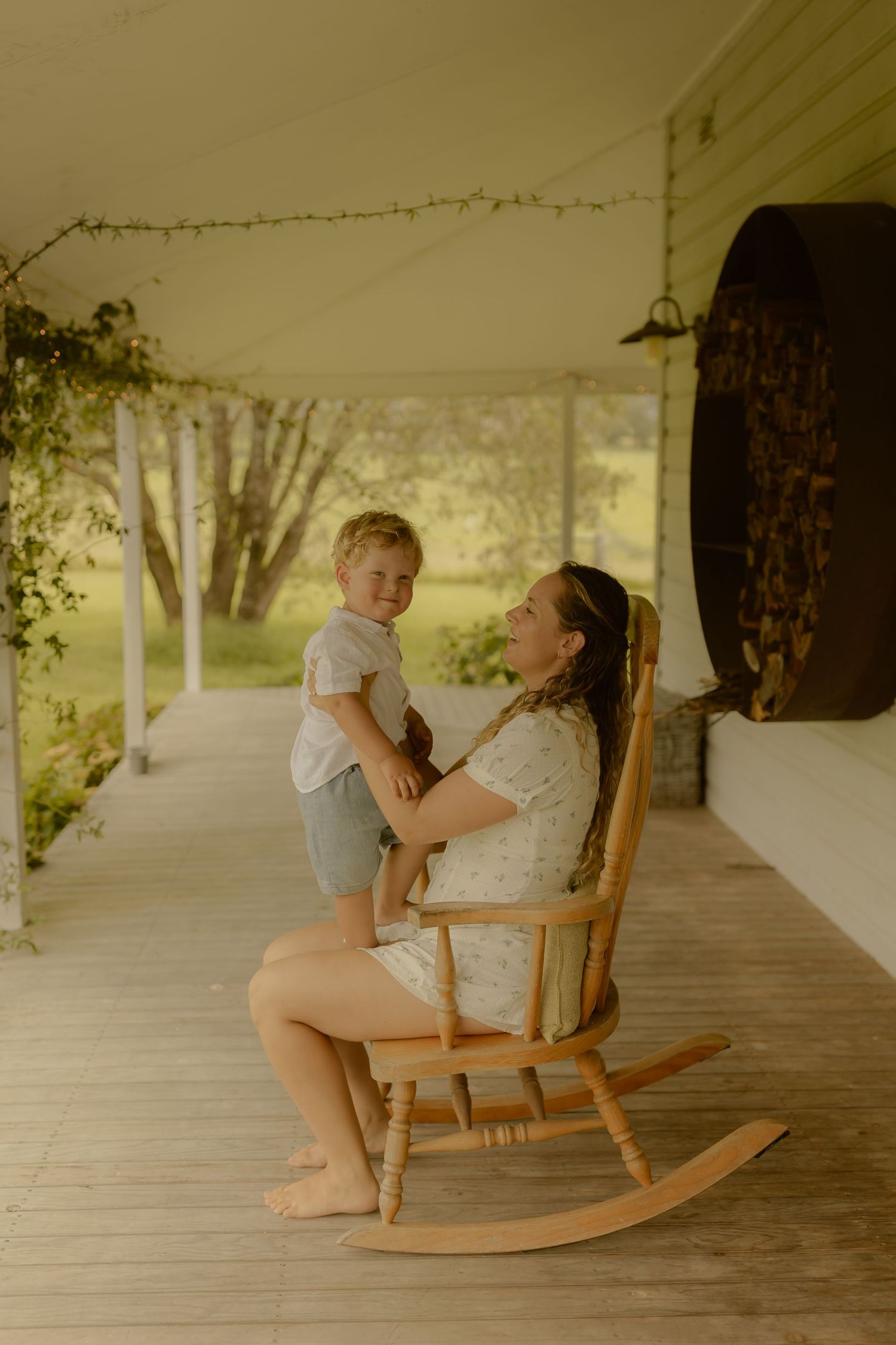 A cozy front porch scene with a wooden rocking chair in warm, natural lighting.