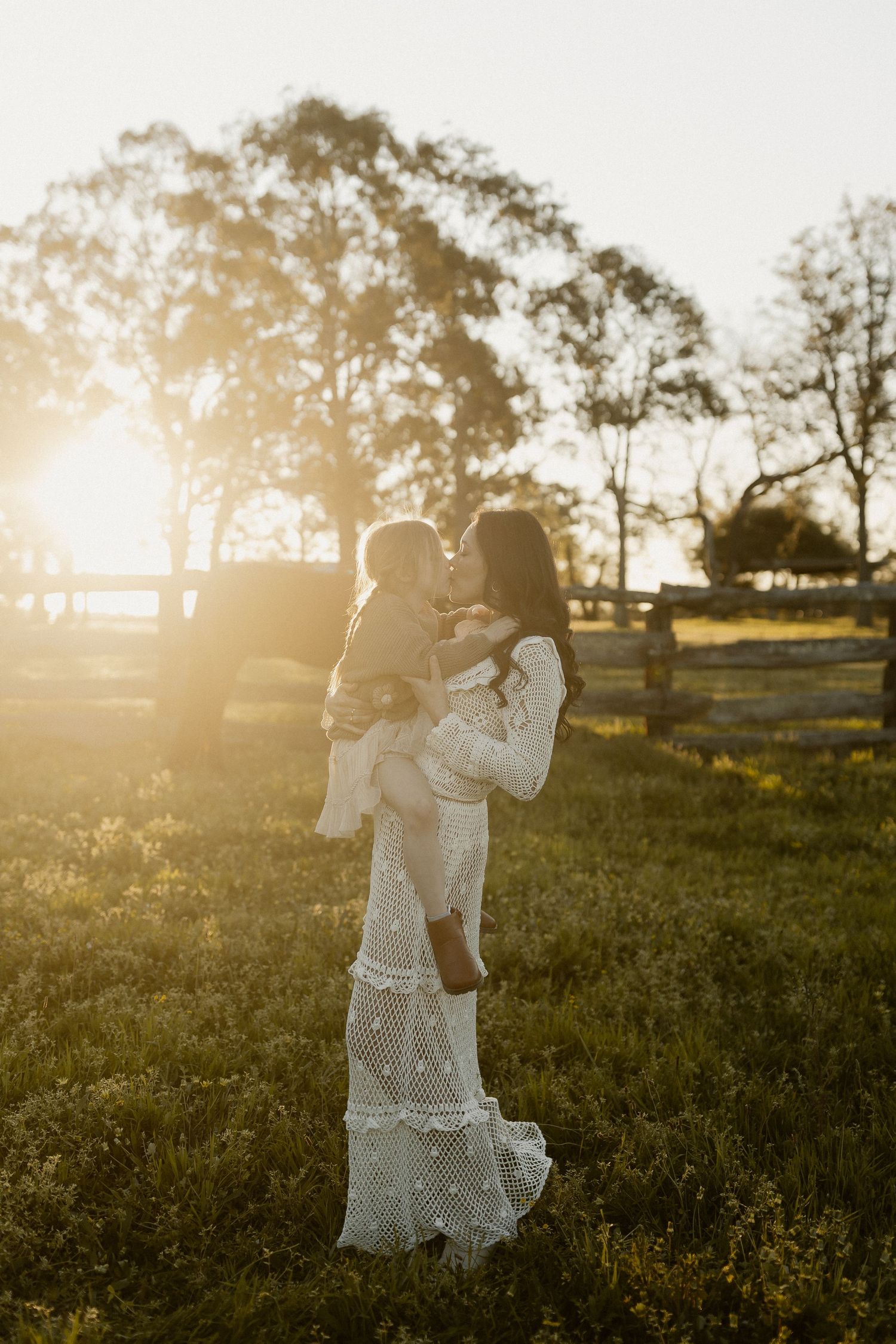 White lace dress twirls gracefully in a sunlit field during golden hour.