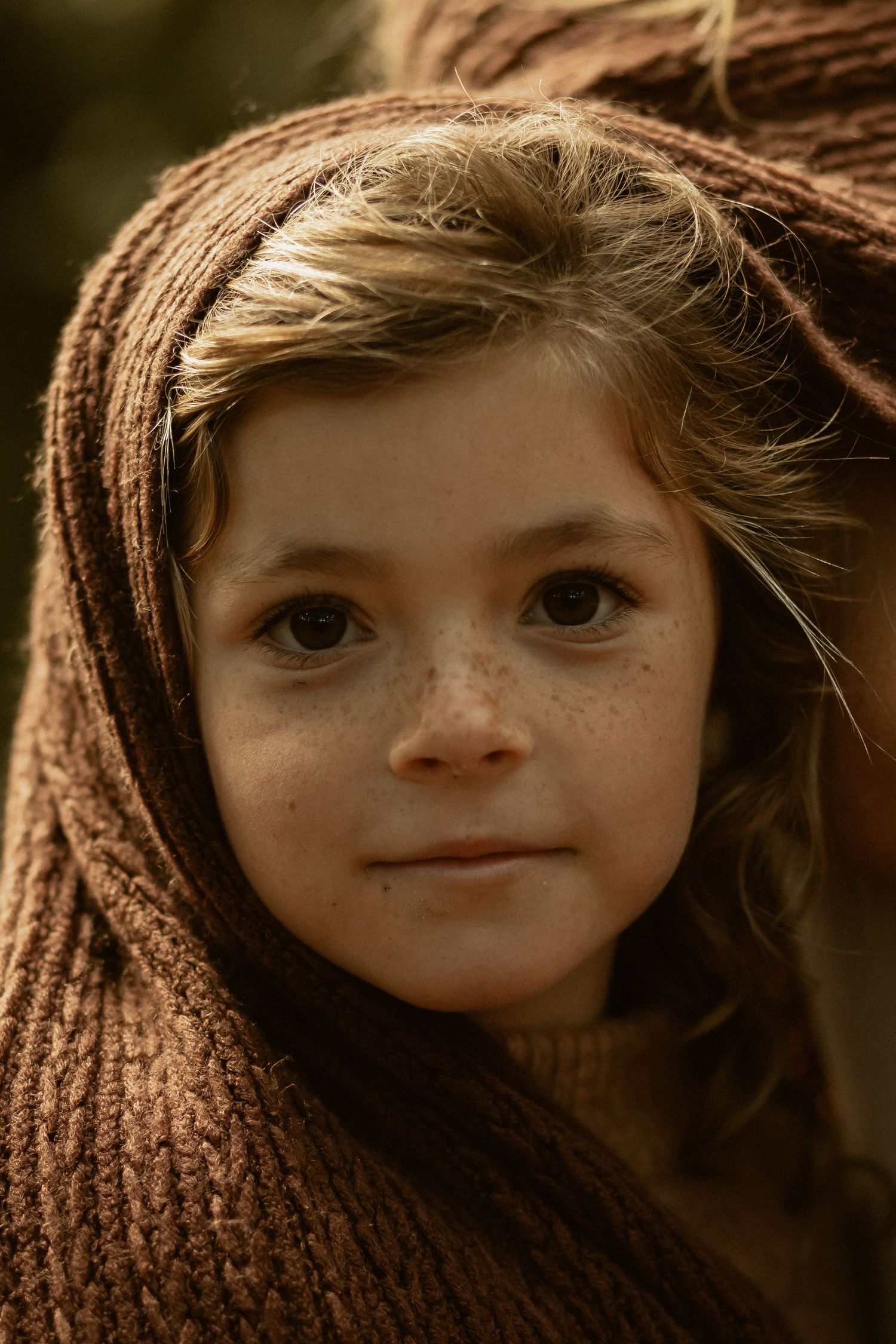 A series of close-up portrait photographs showing a young child's face from different angles in warm lighting.