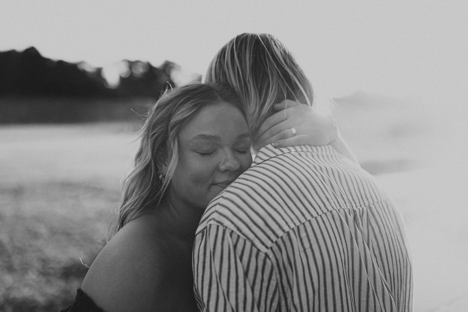 Intimate moment captured in soft natural lighting outdoors.