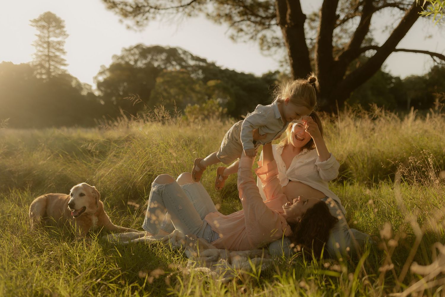 Sun-drenched portrait session in a natural field setting with warm evening light.