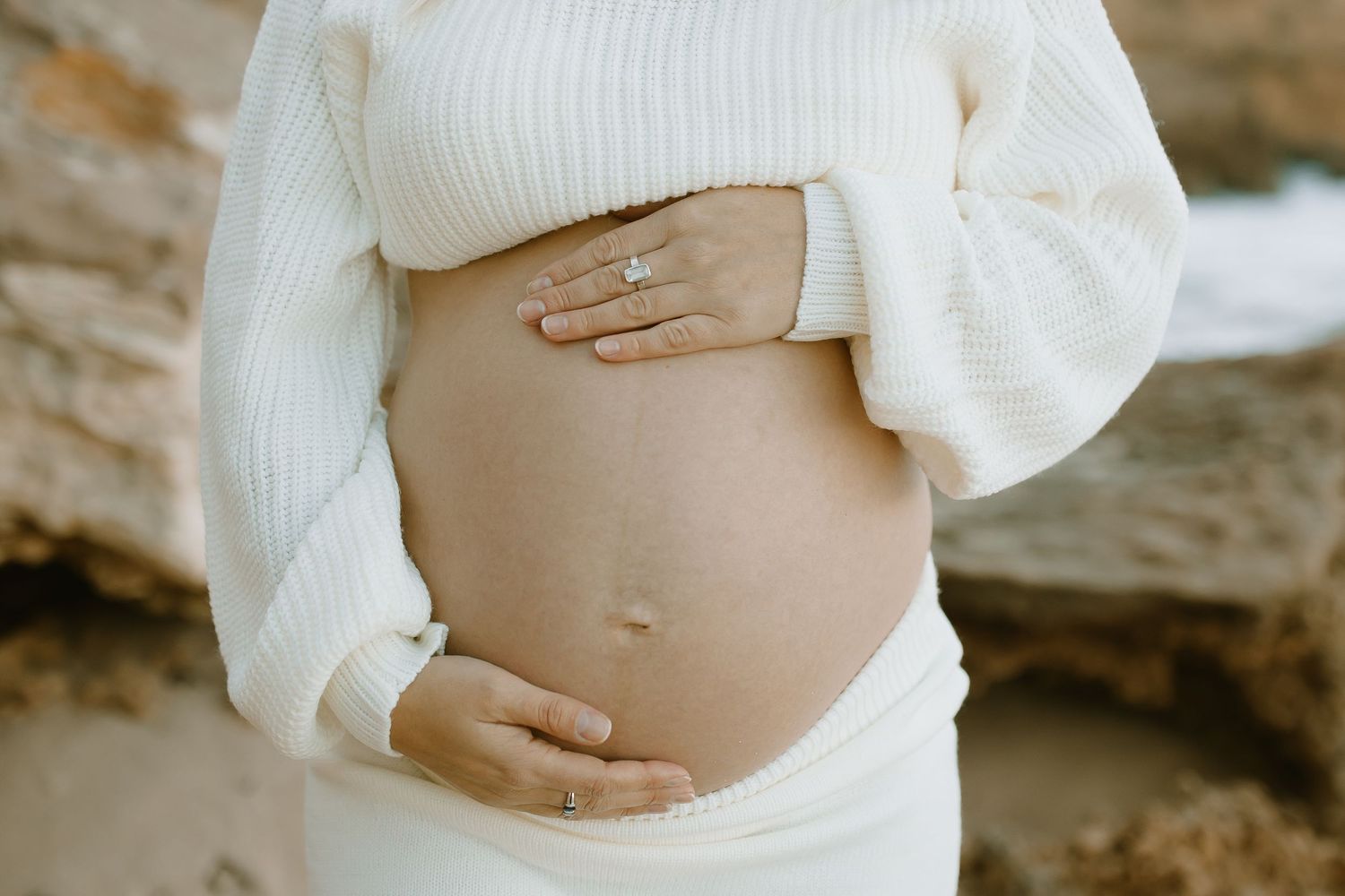 A close up series of pregnancy photos showing a pregnant belly in a white sweater against a natural background.