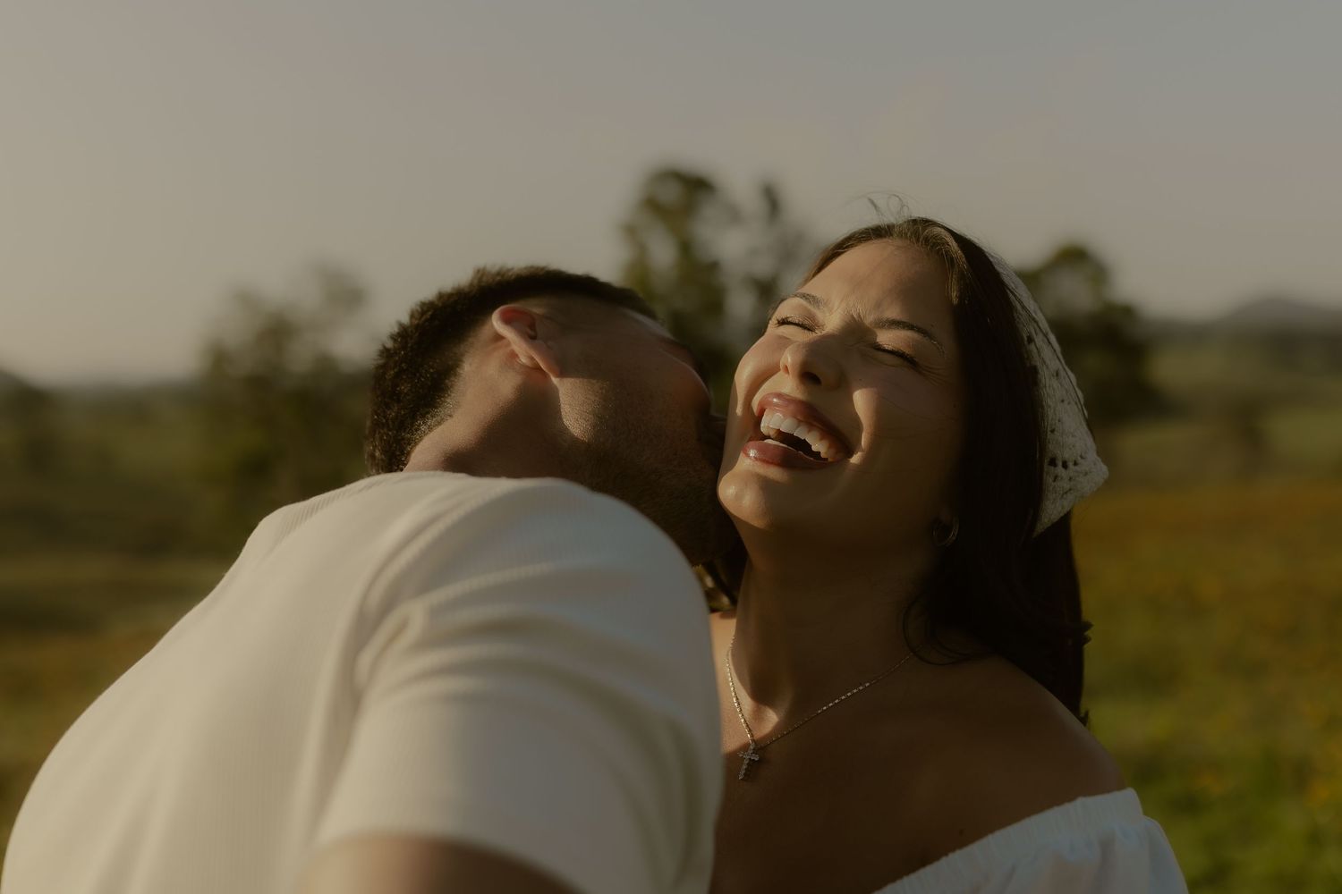 Intimate moment between couple captured in warm sunset lighting.