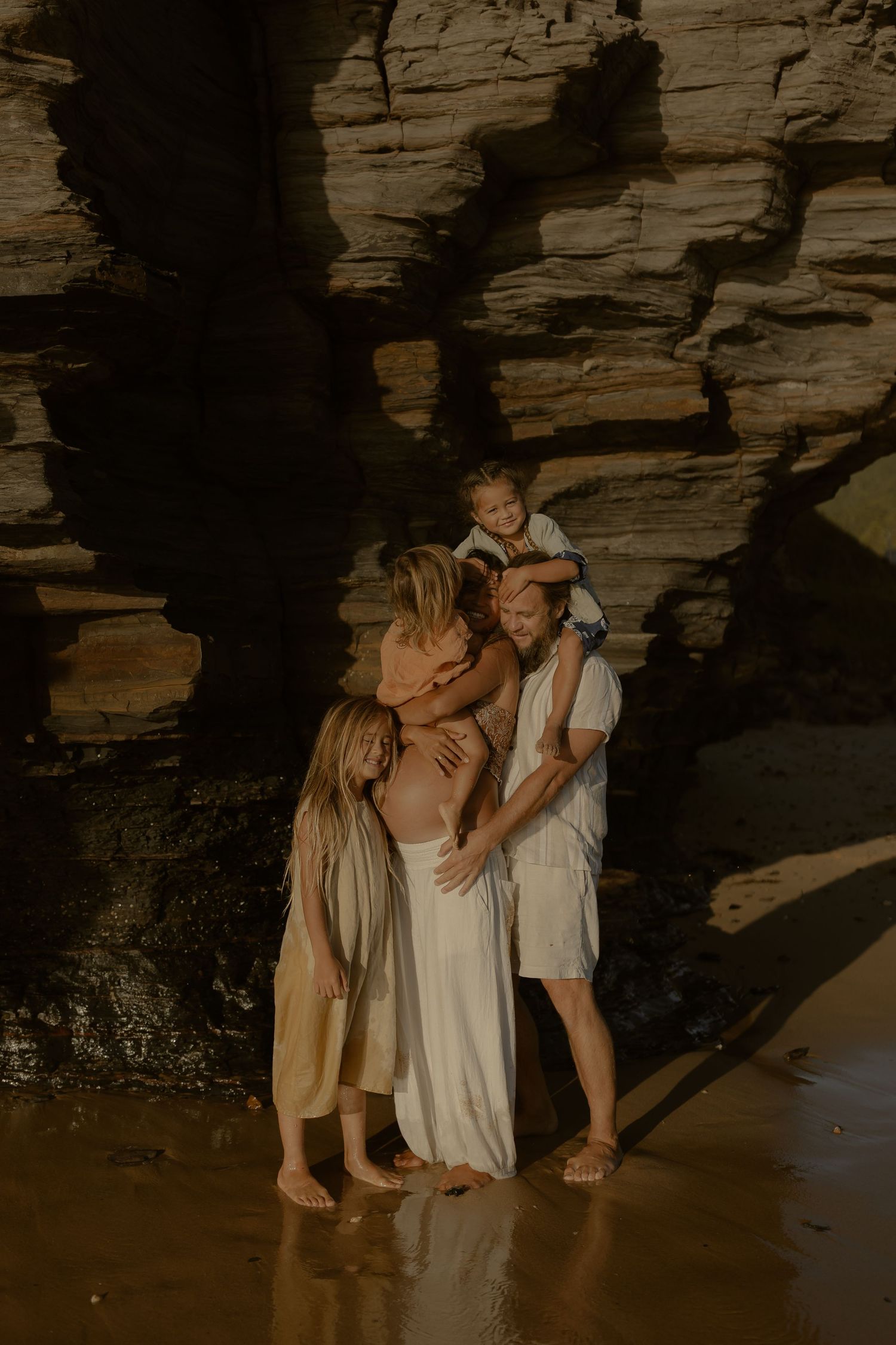 A tender family moment captured in the shadows of towering cave walls.