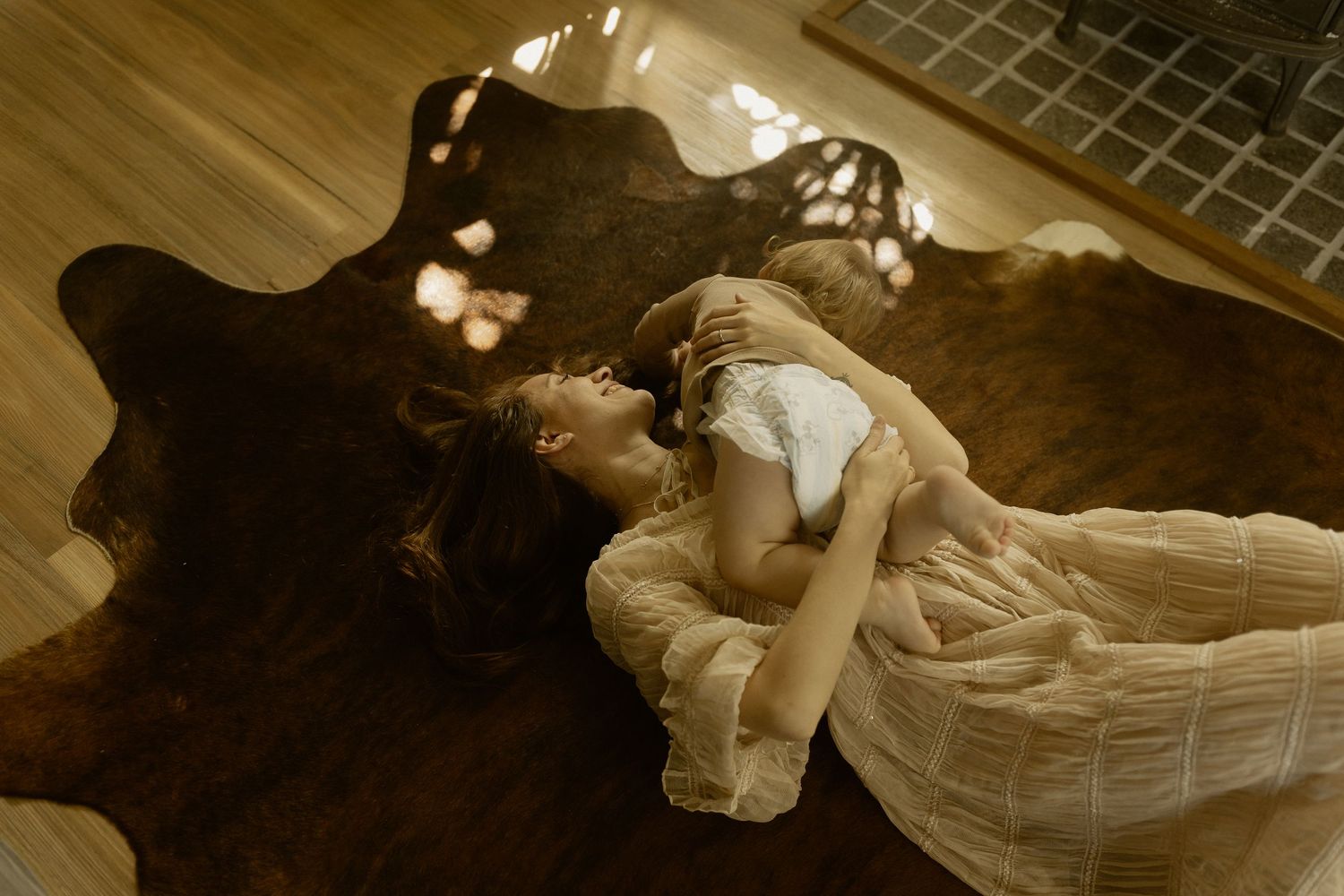Flowing dress movements captured in dramatic sepia lighting on hardwood floor.
