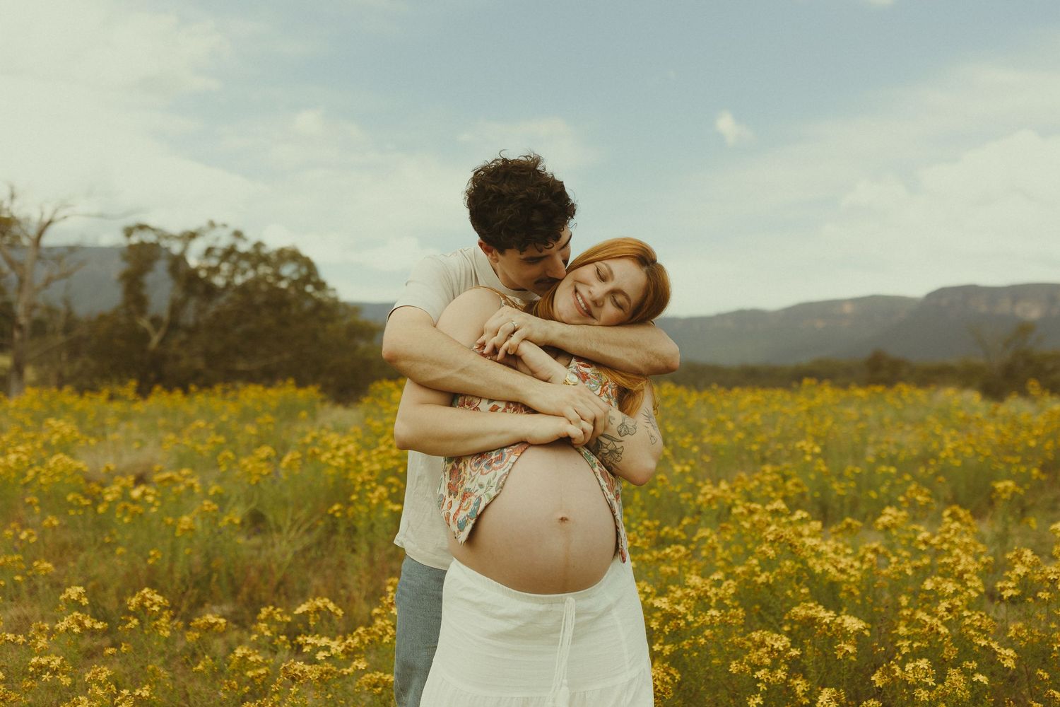 Intimate moment captured in a sunlit meadow filled with yellow wildflowers.