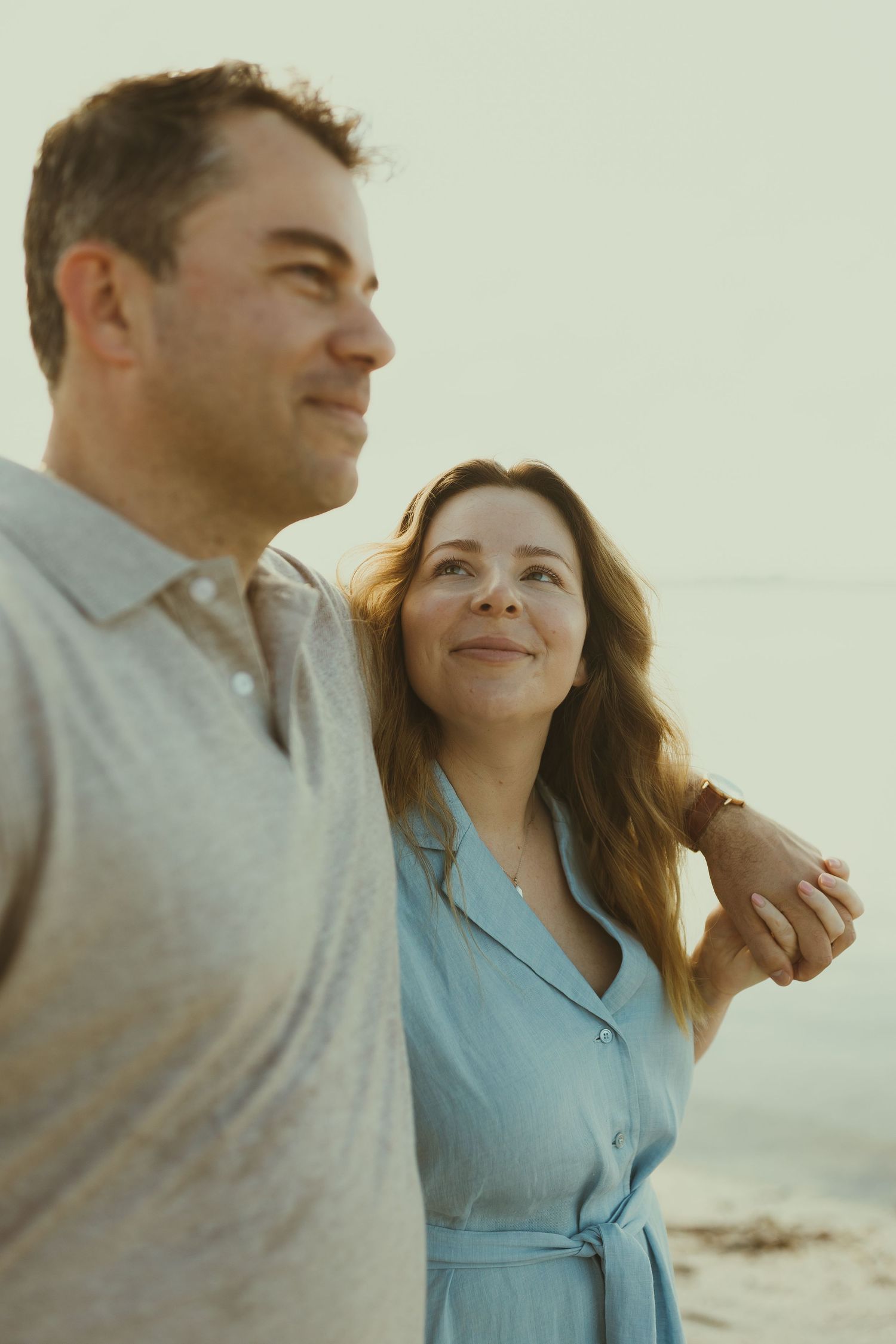 Couple enjoying a tender moment together on the beach during golden hour.