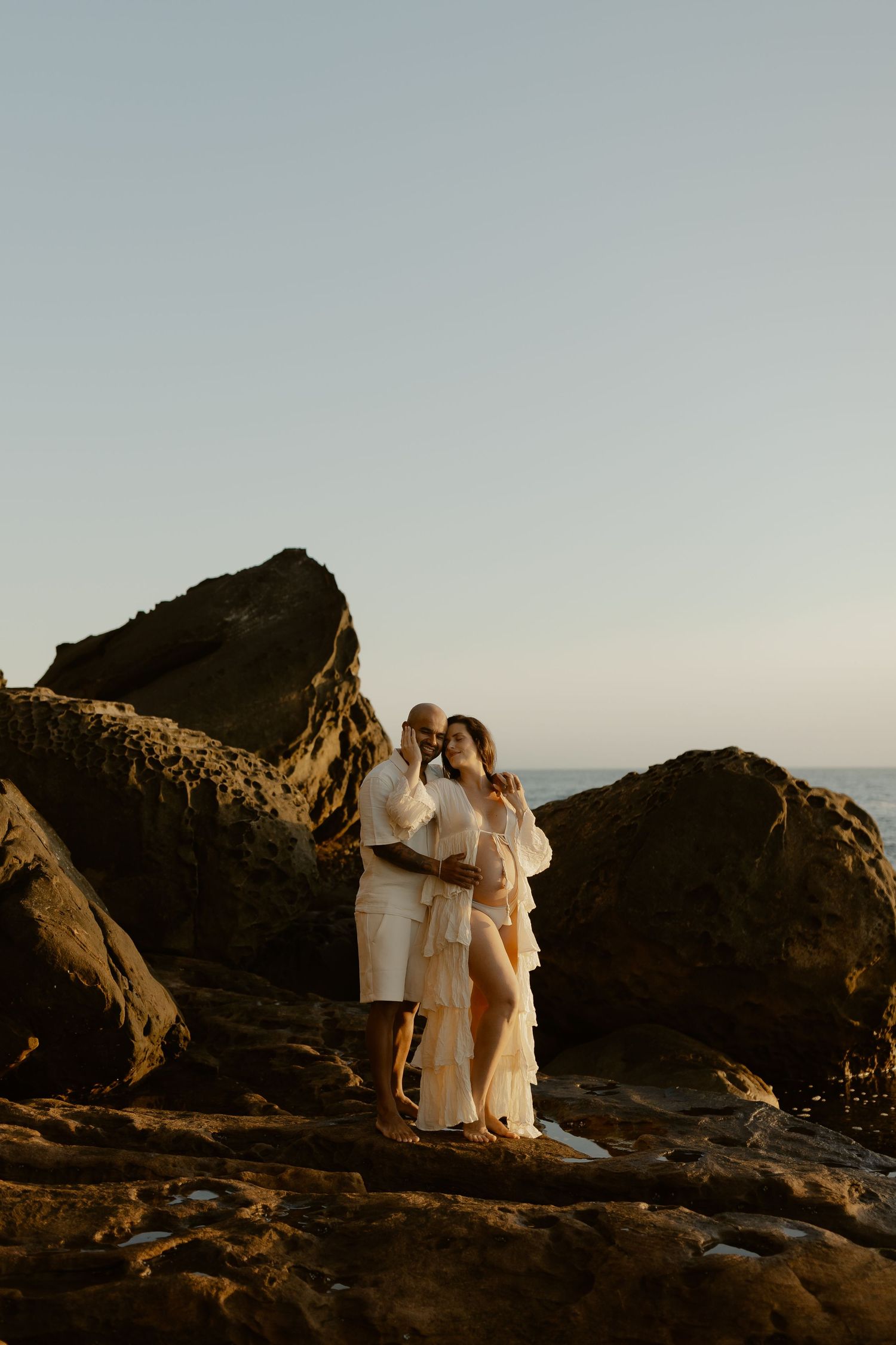 A series of scenic coastal wedding photos at sunset with rocky cliffs and dramatic ocean views in the background.