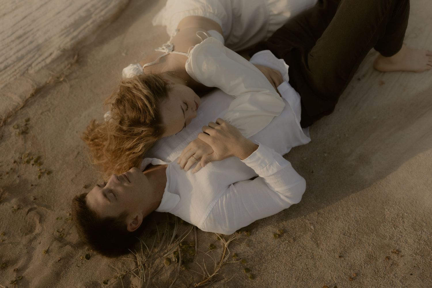A person lies on a concrete floor in a white shirt while performing a dynamic dance or movement sequence.