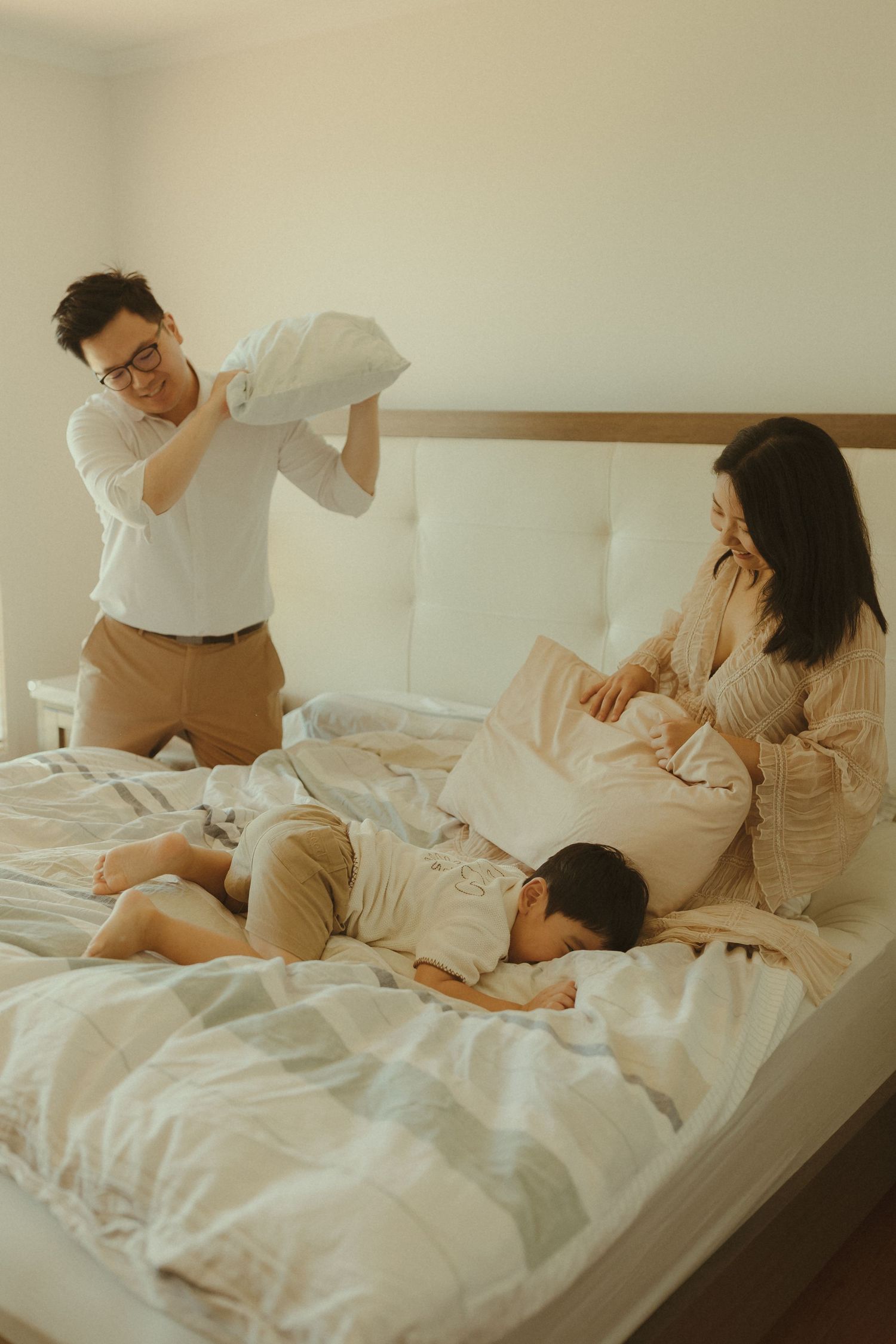 Family enjoying quality time together on a cozy bed in a bright room.
