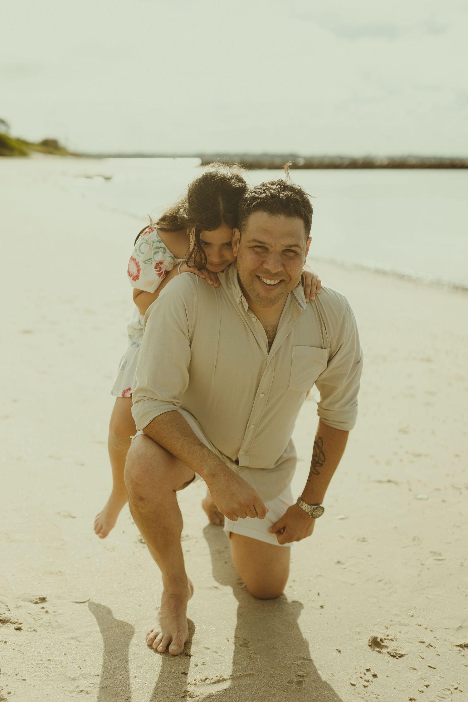Candid moment of family fun and laughter while playing on a sunny beach.
