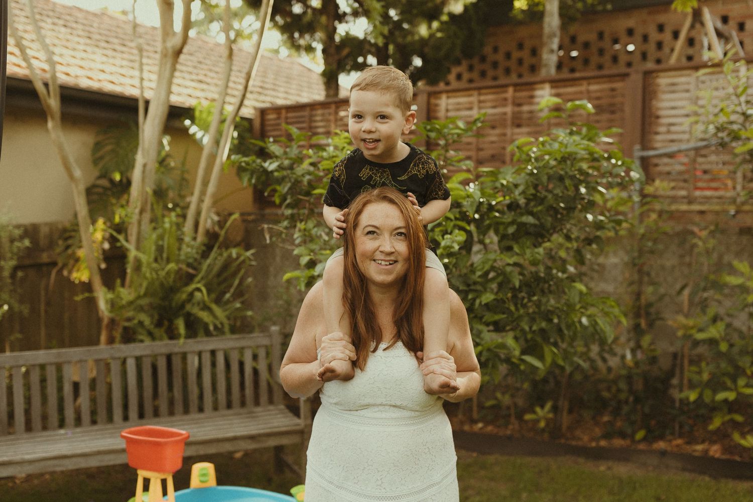 Family enjoying outdoor activities in a backyard garden setting.
