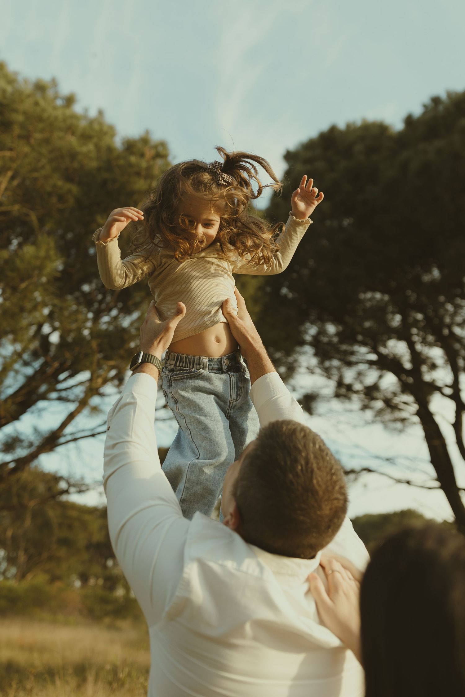 Joyful moment captured as one person lifts another in an outdoor setting.