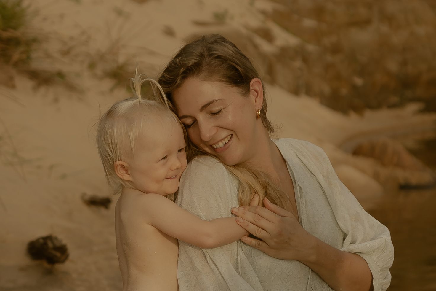 A romantic couple shares tender moments in a desert landscape during golden hour.