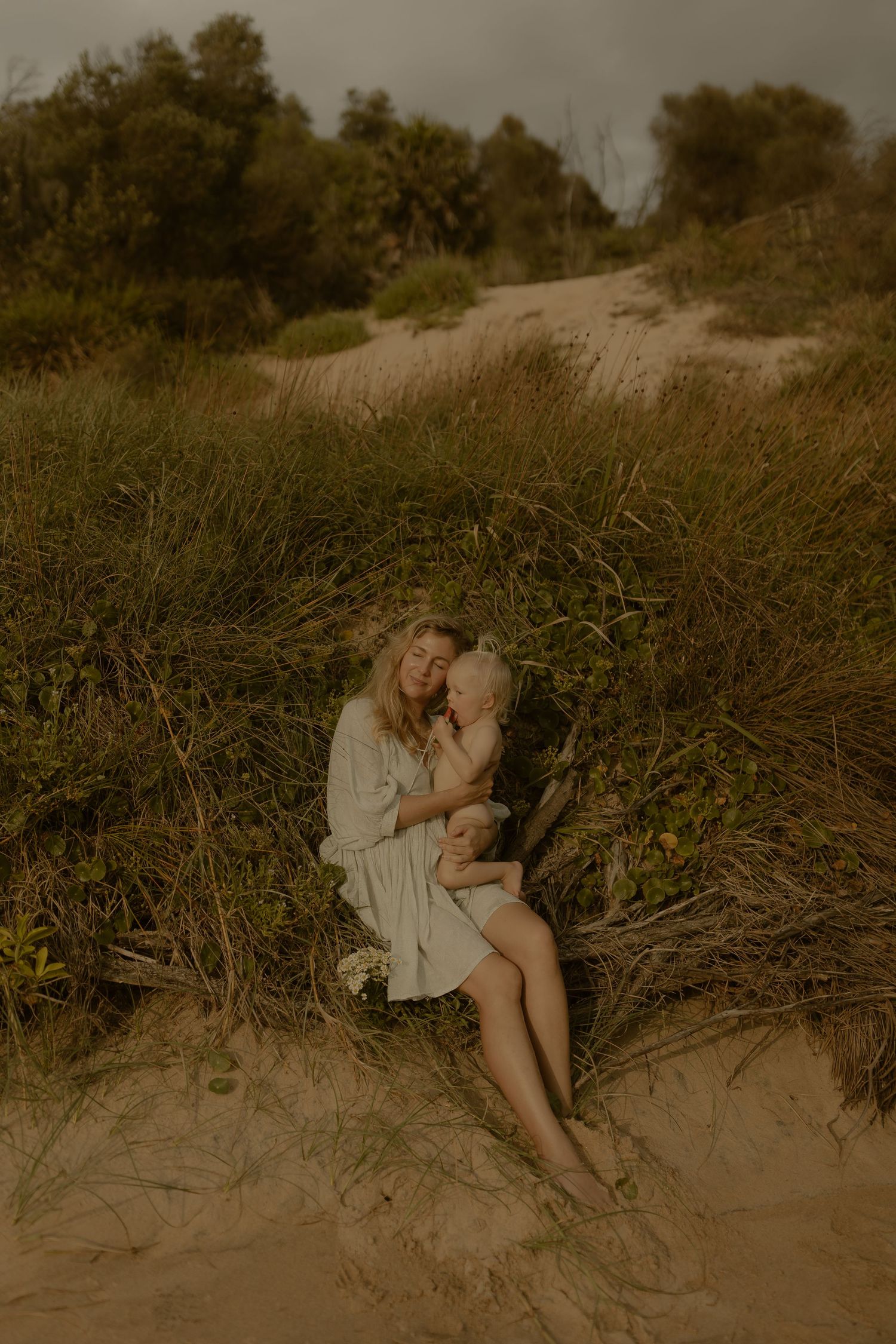 Atmospheric sepia photographs showing quiet moments on a sandy beach with tall grass.