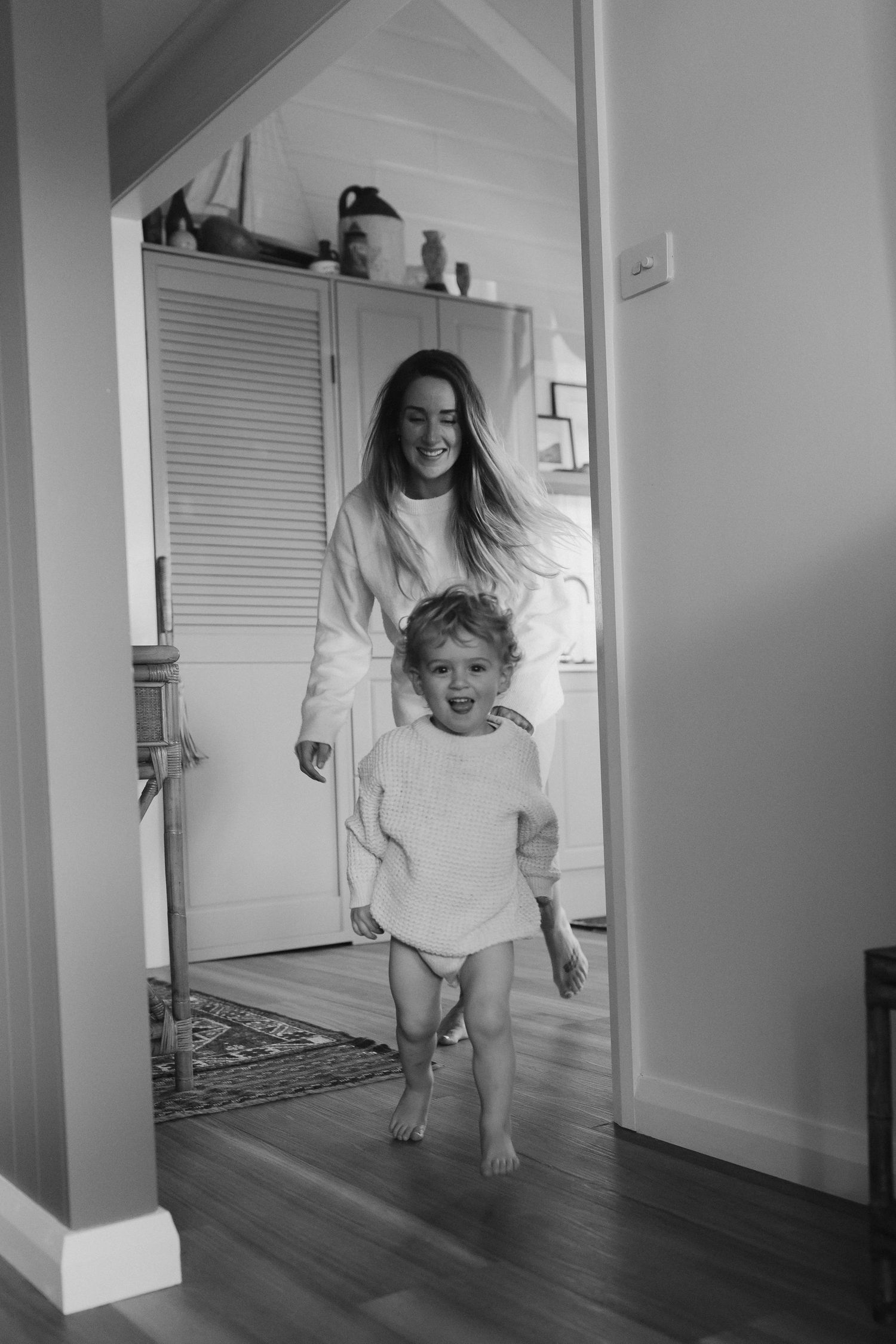 Playful sequence of people jumping and running through a bright hallway in white clothing.
