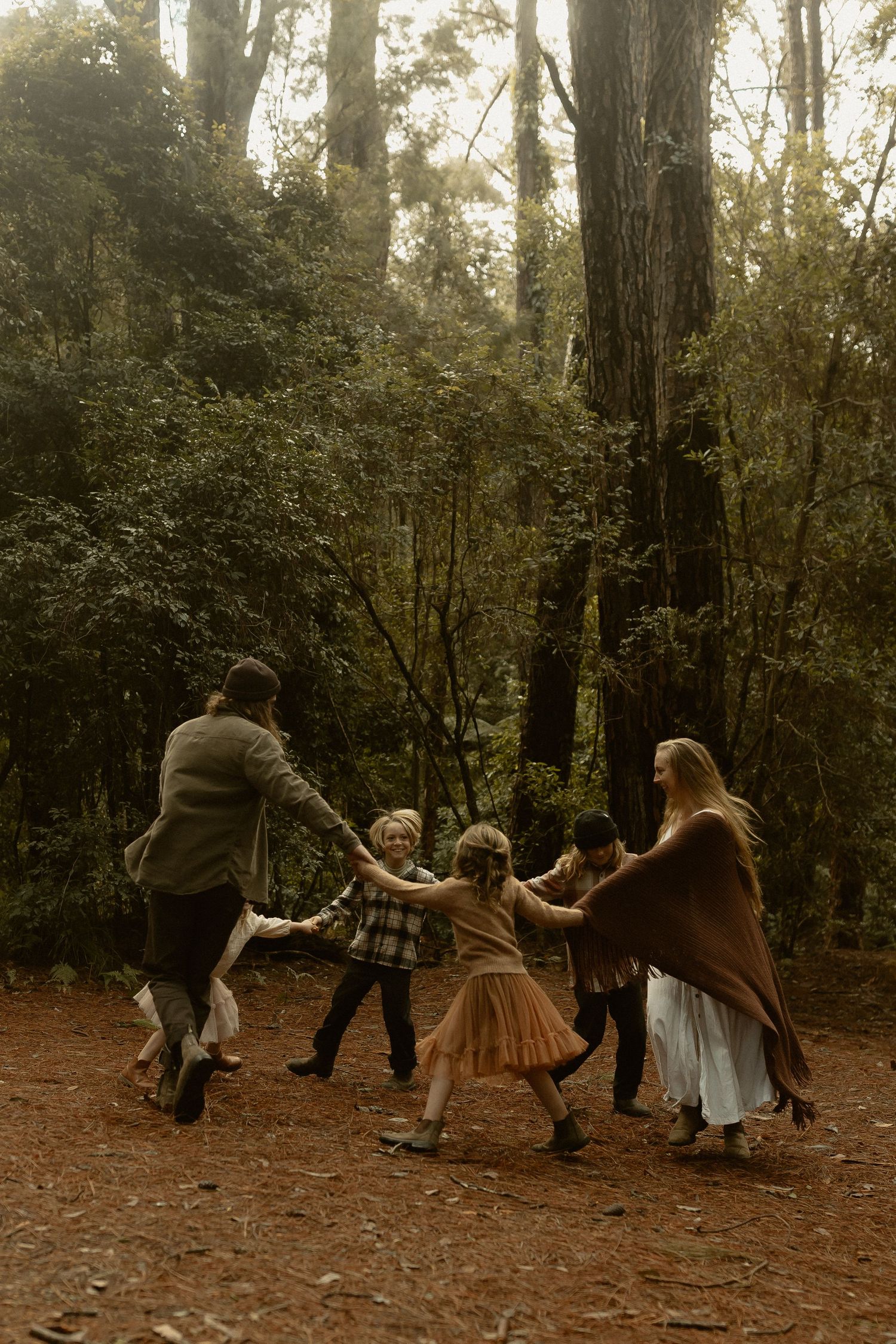 A joyful dance circle in a wooded forest clearing with warm autumn lighting.