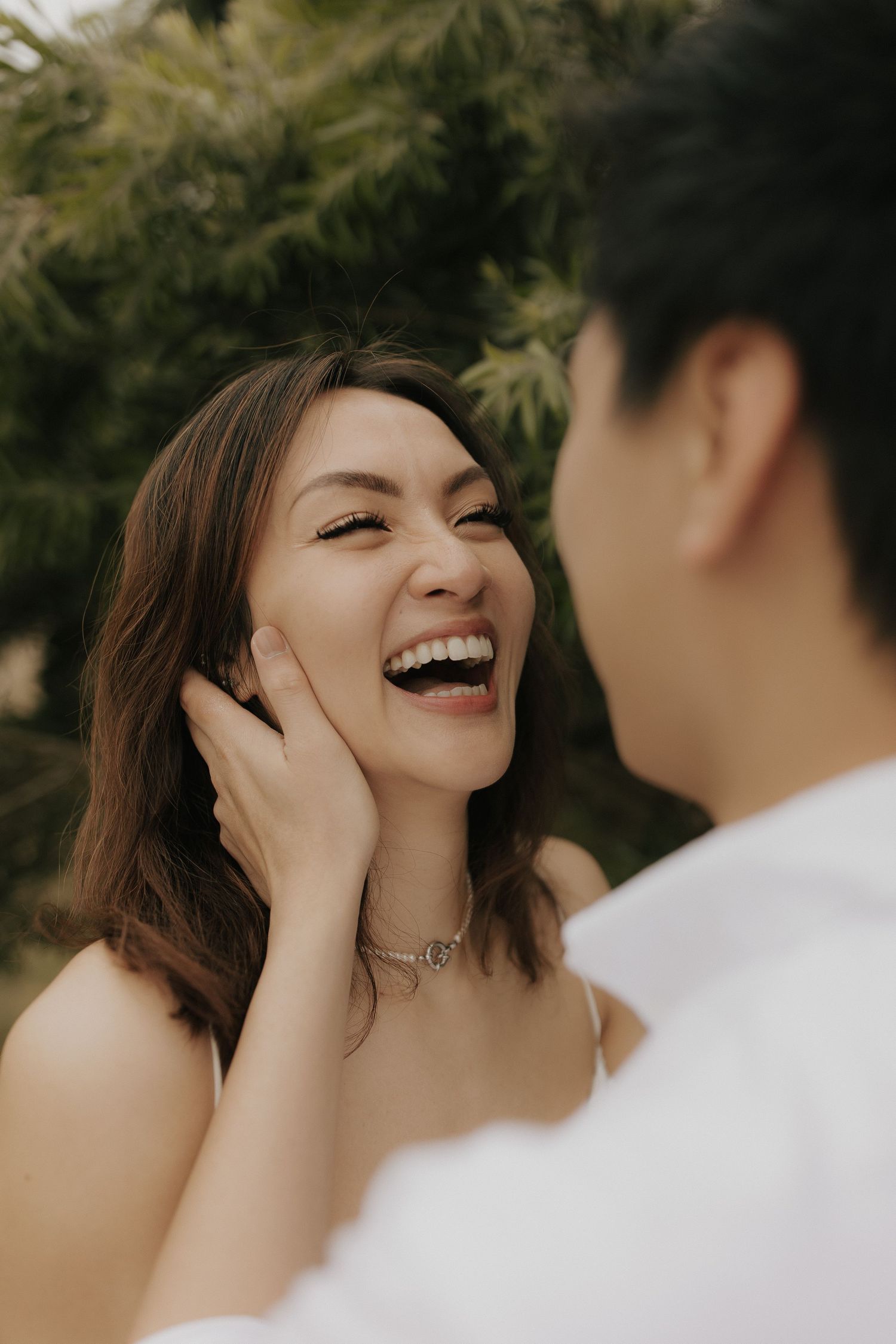 An intimate close-up of a couple sharing a tender moment against a natural backdrop.