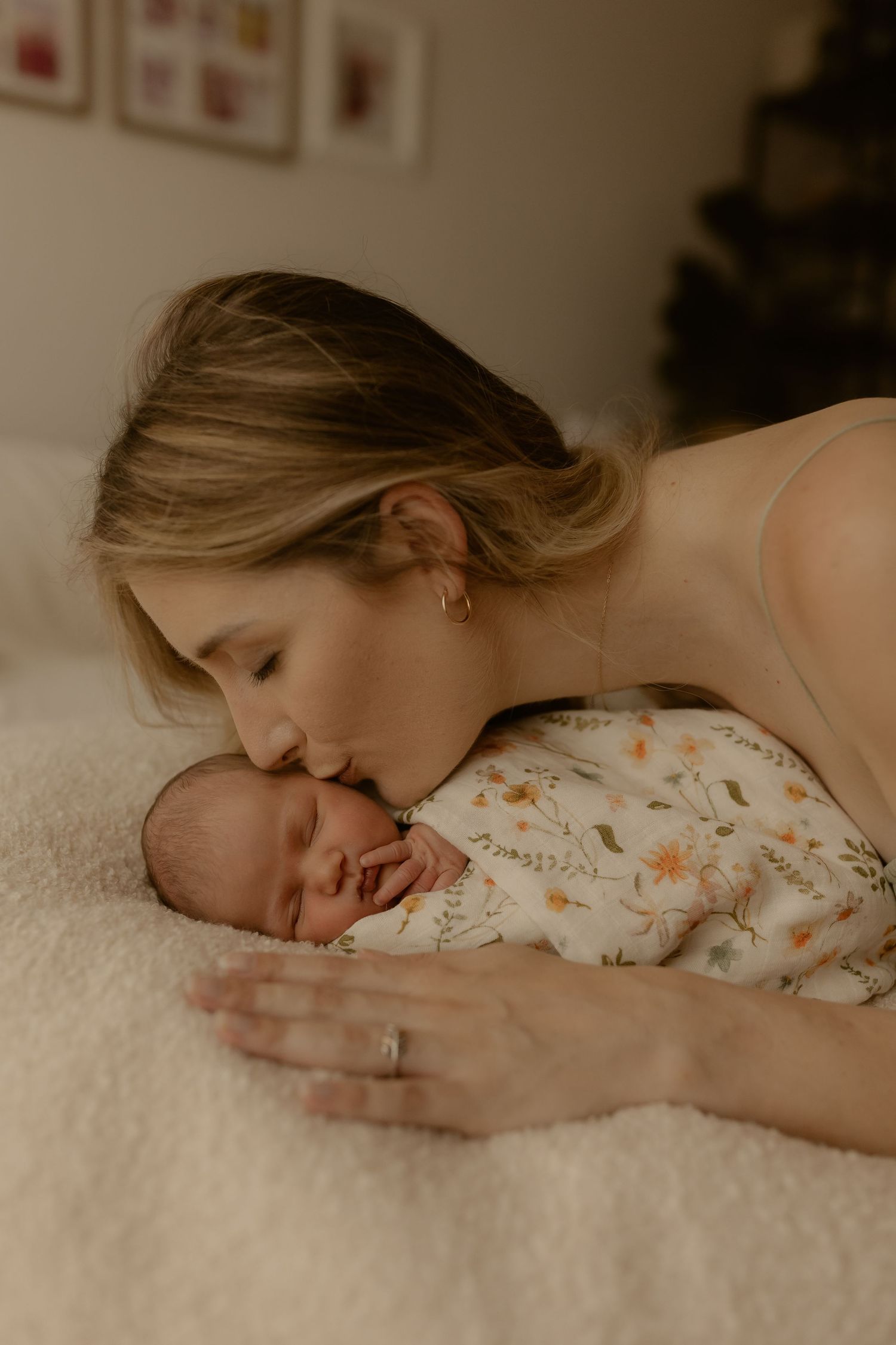 Intimate portrait of parent and sleeping baby lying together on white textured blanket.
