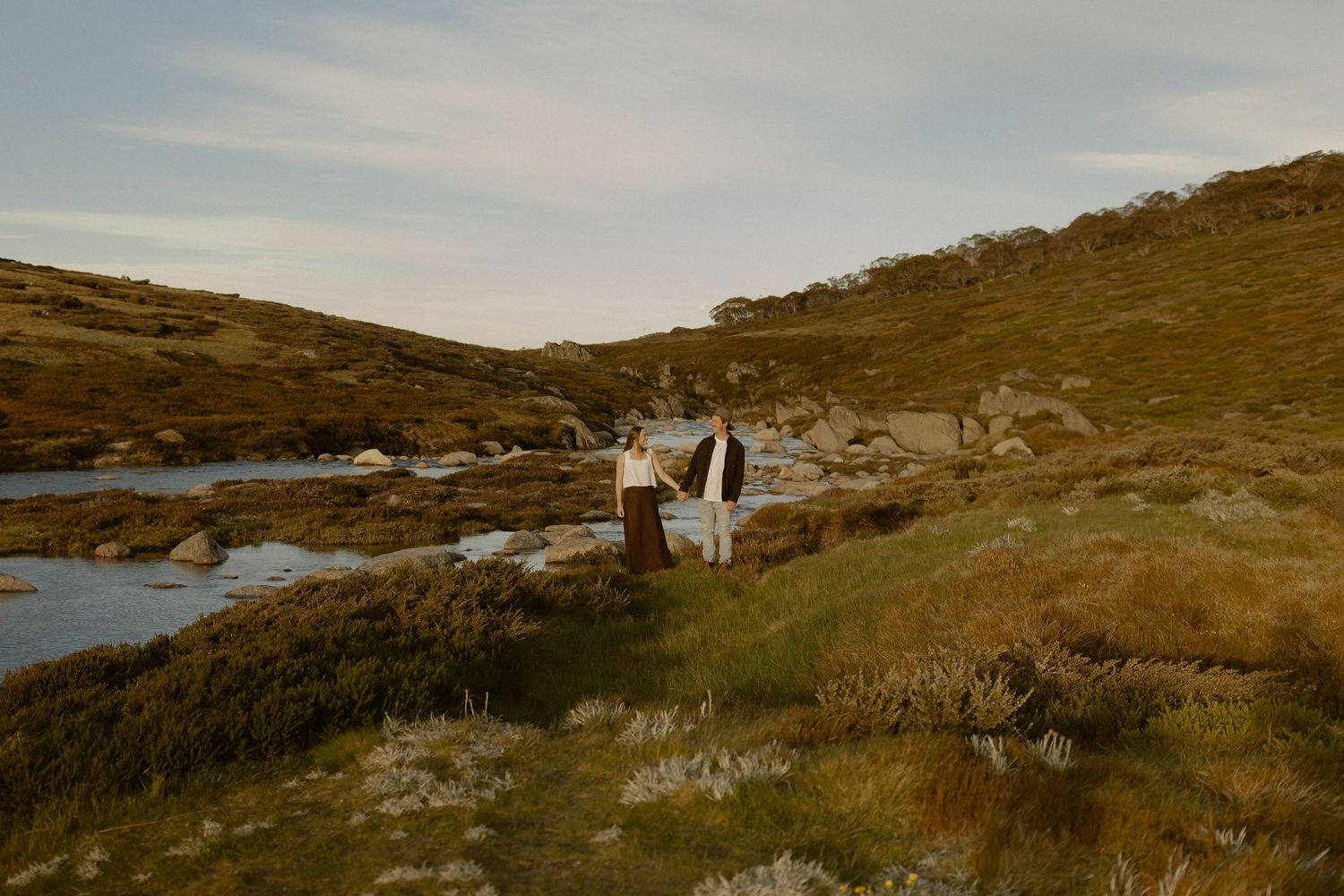 Scenic panoramic view of a rugged coastal landscape with rolling hills and water.