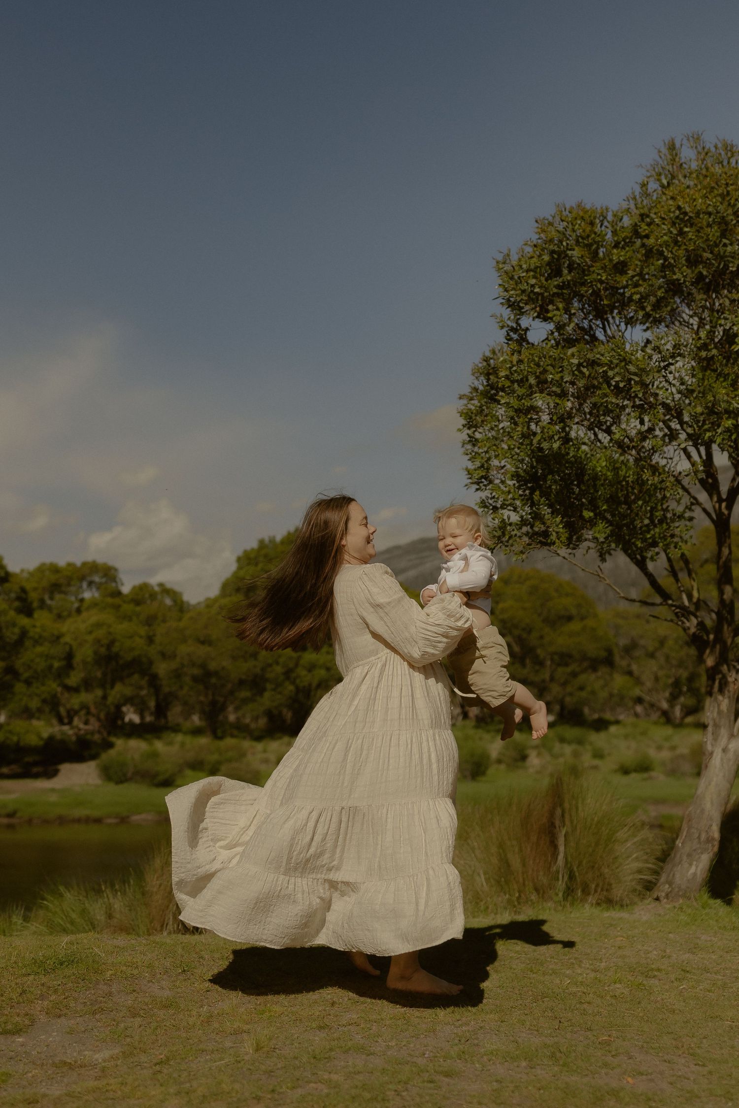 A joyful scene of dancing and twirling in a flowing dress against a natural landscape.