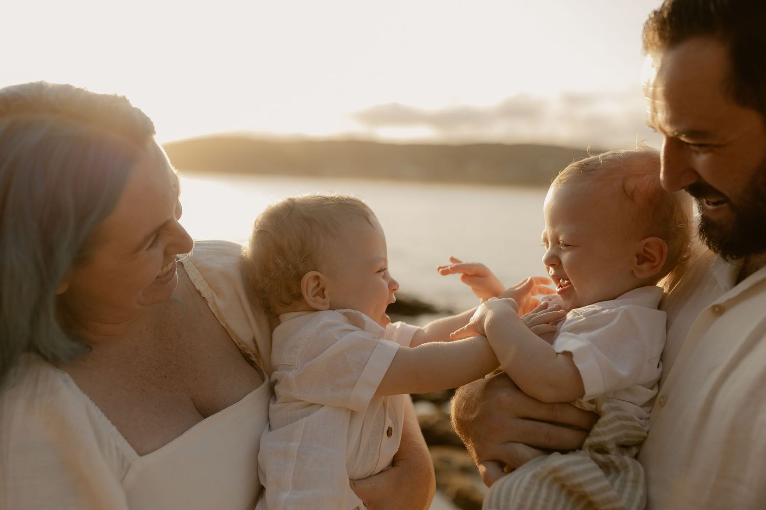 Candid family interactions captured in warm golden light by the ocean.