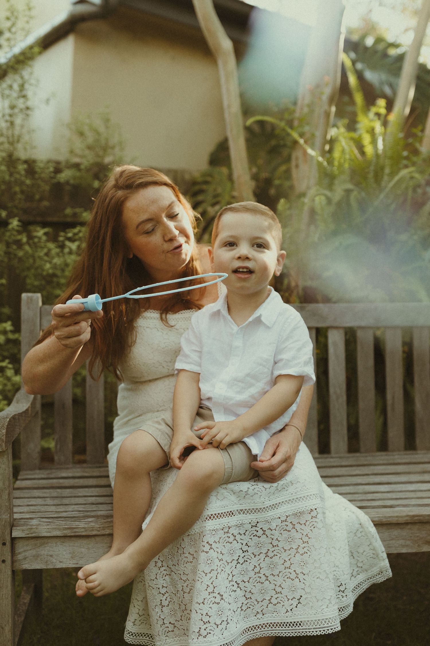 Warm summer evening photos on a garden bench showing sweet family moments.