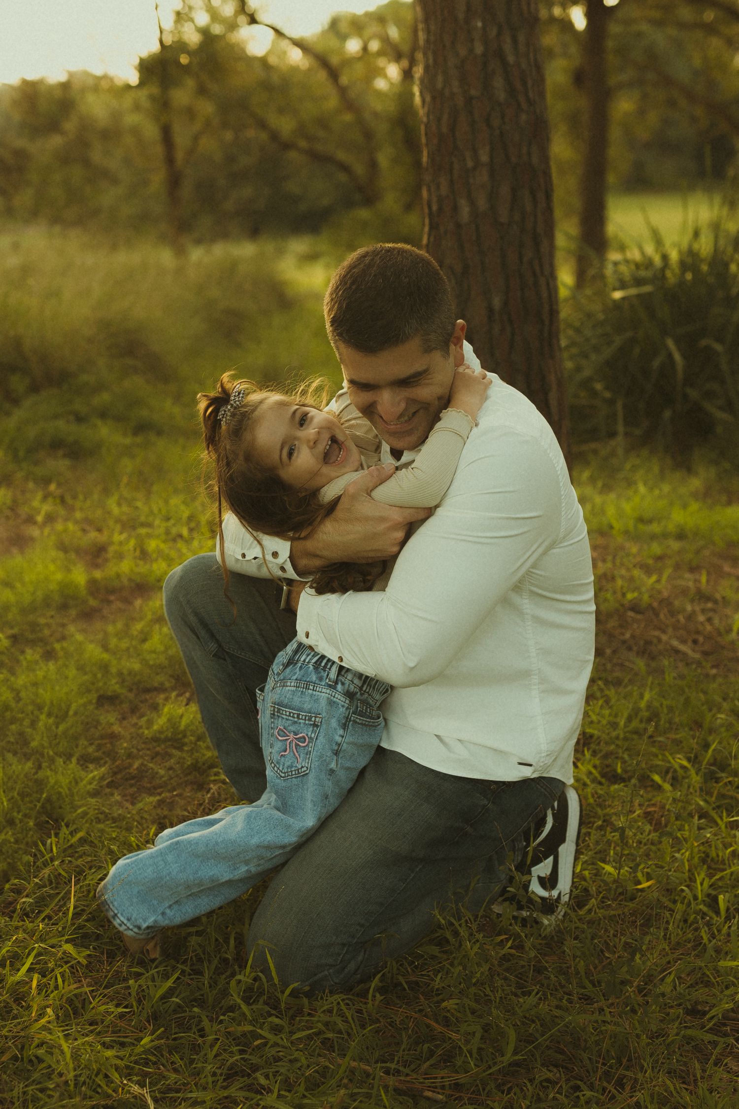 Tender moment captured between parent and child embracing in golden sunset light.