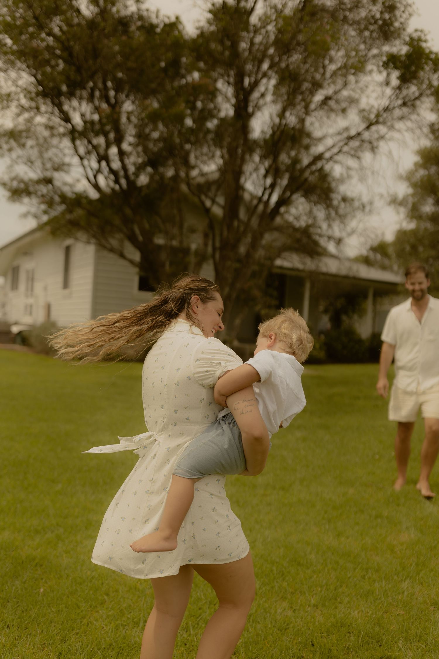 People playing and embracing on a green lawn.