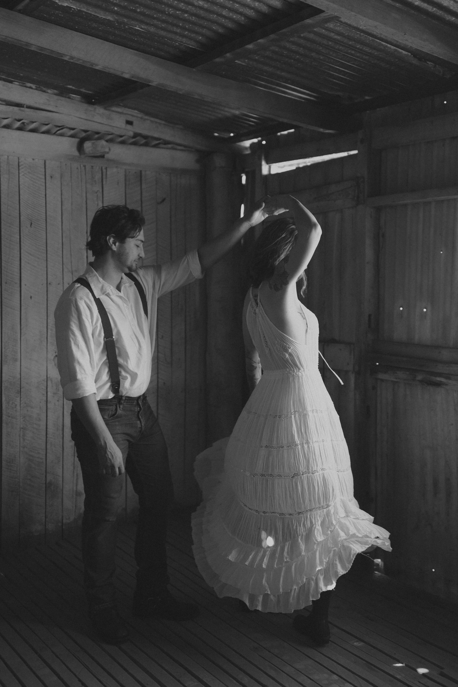 A series of black and white photos showing a couple dancing in a rustic wooden room with dramatic lighting.
