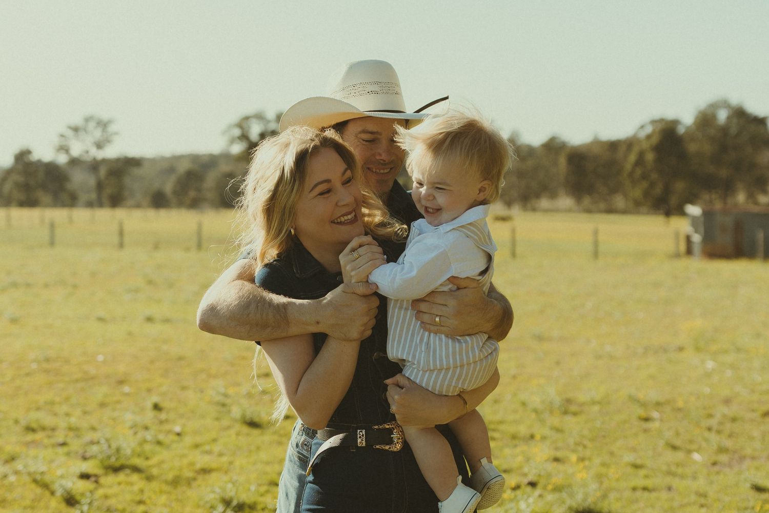 A tender embrace captured in warm sunlight on a countryside farm.