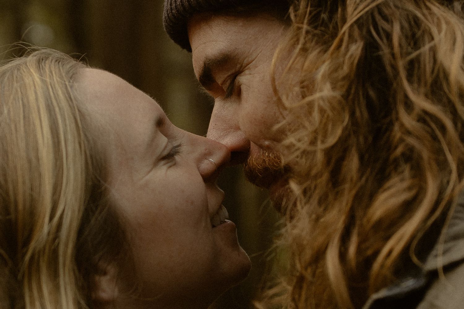 A romantic close-up shot of a couple sharing an intimate moment with their faces nearly touching.